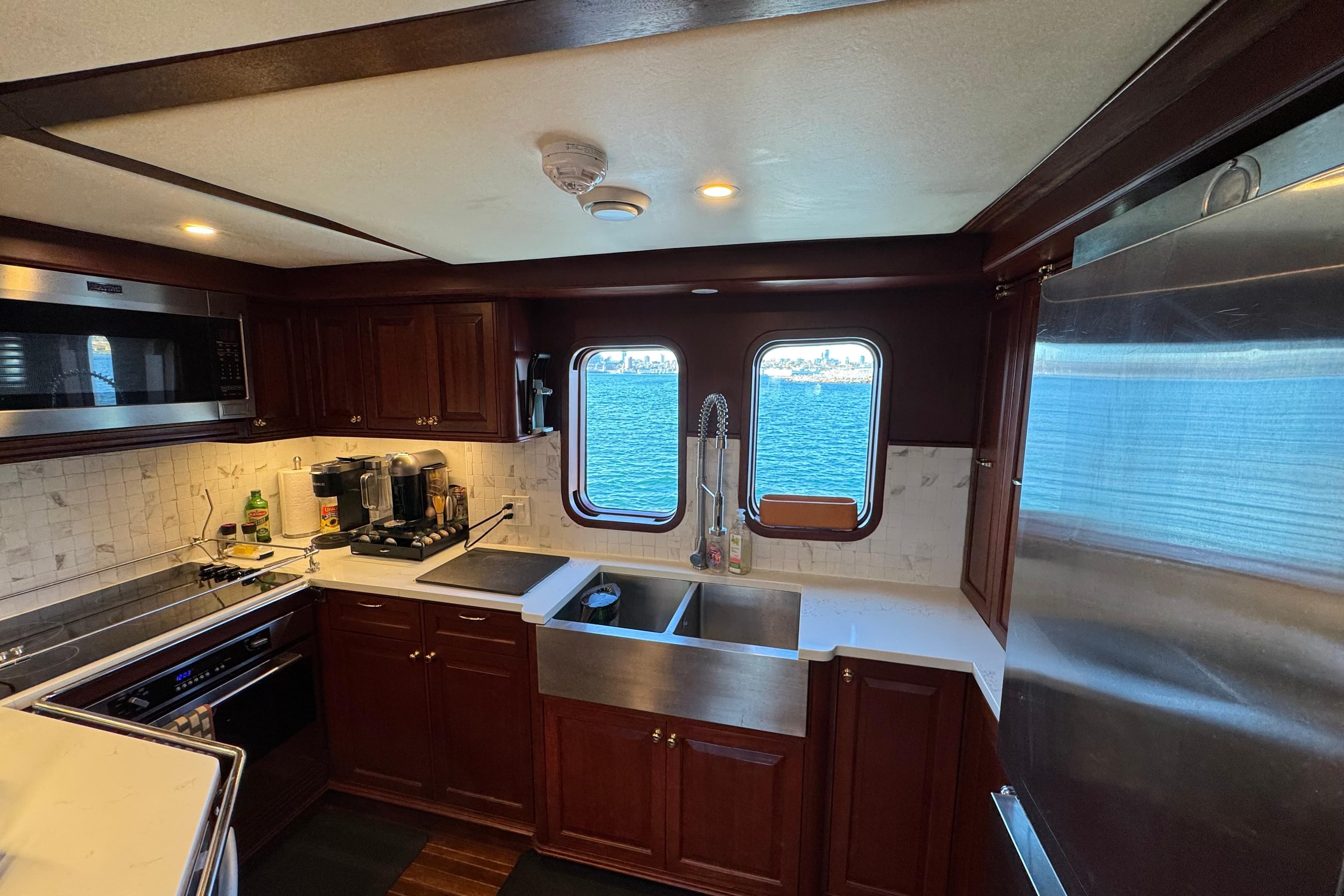 Luxurious yacht kitchen with wooden cabinets, stainless steel appliances, and ocean view windows. Doogersbank Vipack 2001.