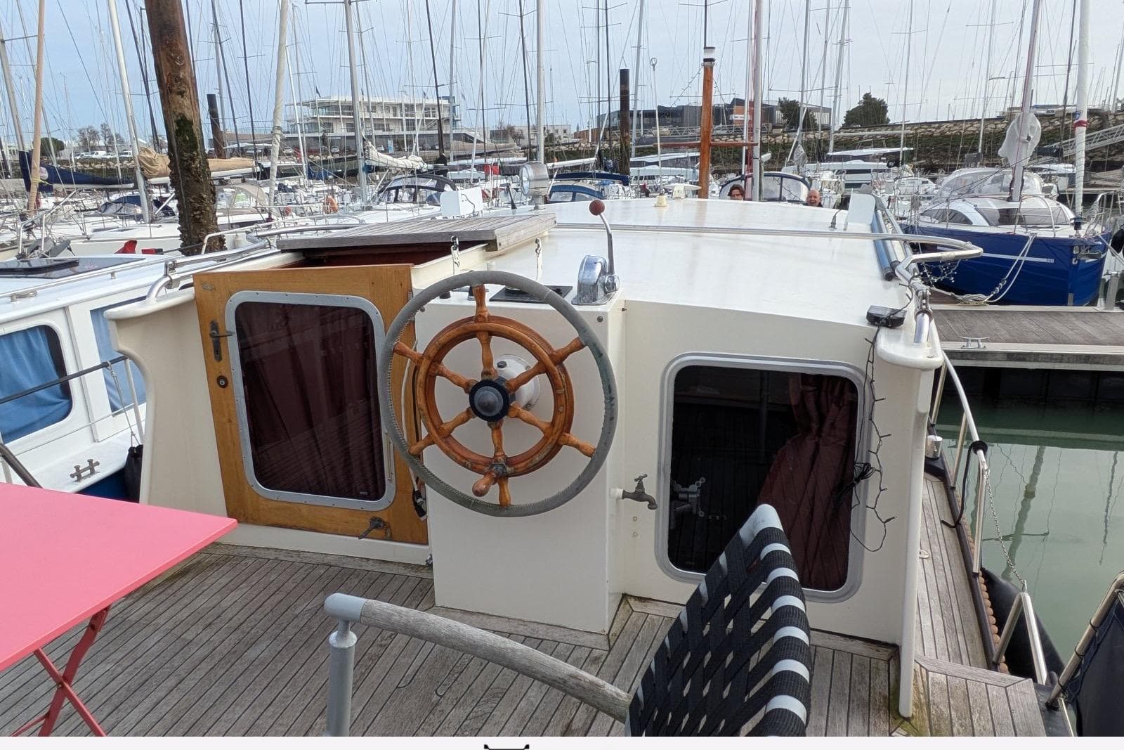 1987 Linssen Vlet 1000 boat docked in marina, featuring wooden steering wheel and deck seating.