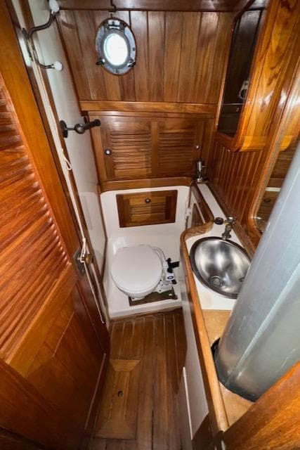 1986 Cabo Rico CB38 yacht bathroom with wooden interior and stainless steel sink.