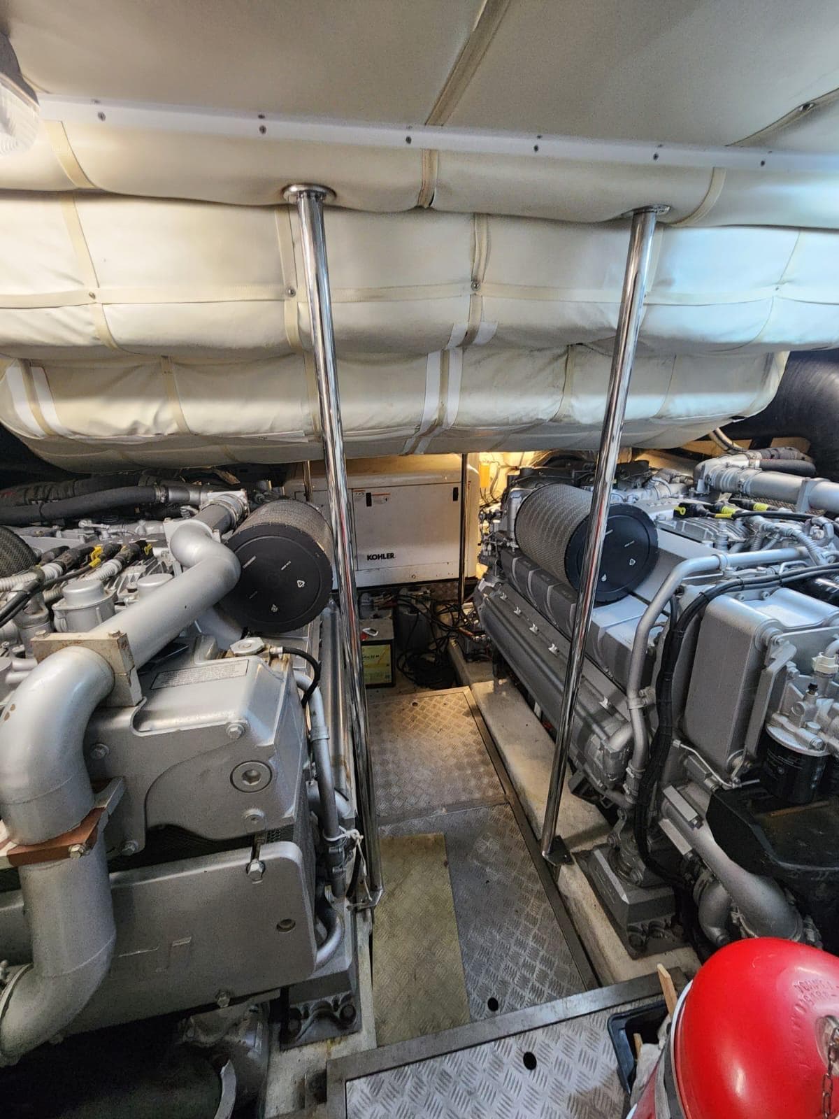 Engine room of a 2011 Pershing 72 yacht, showcasing dual engines and mechanical components.