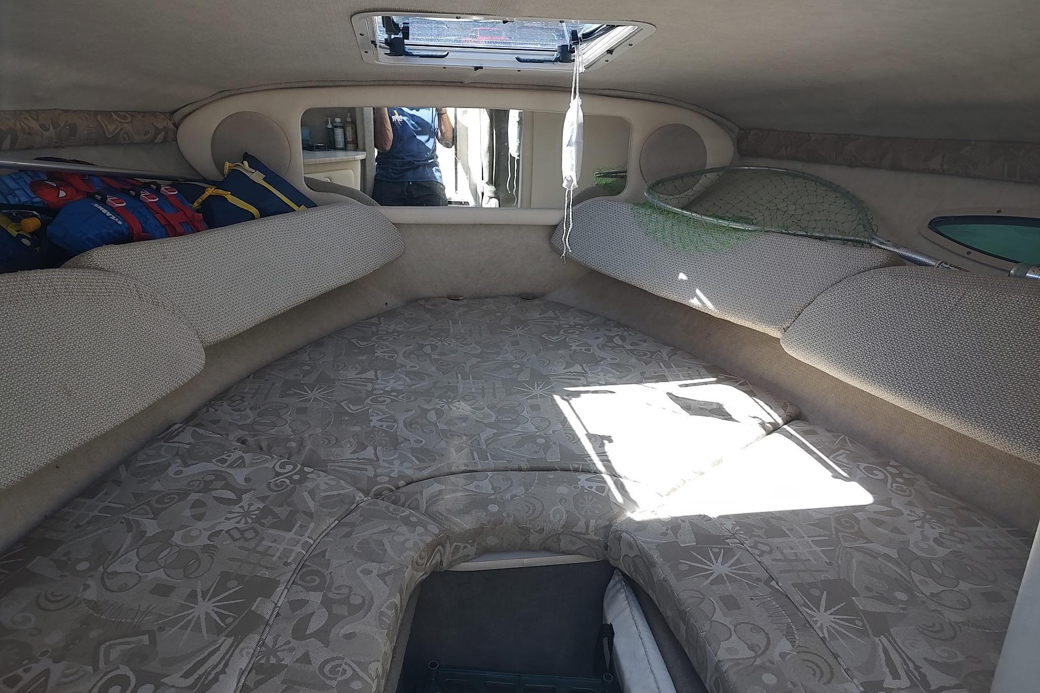 Interior cabin of 2004 Sea Ray 215 Weekender boat with cushions and storage.