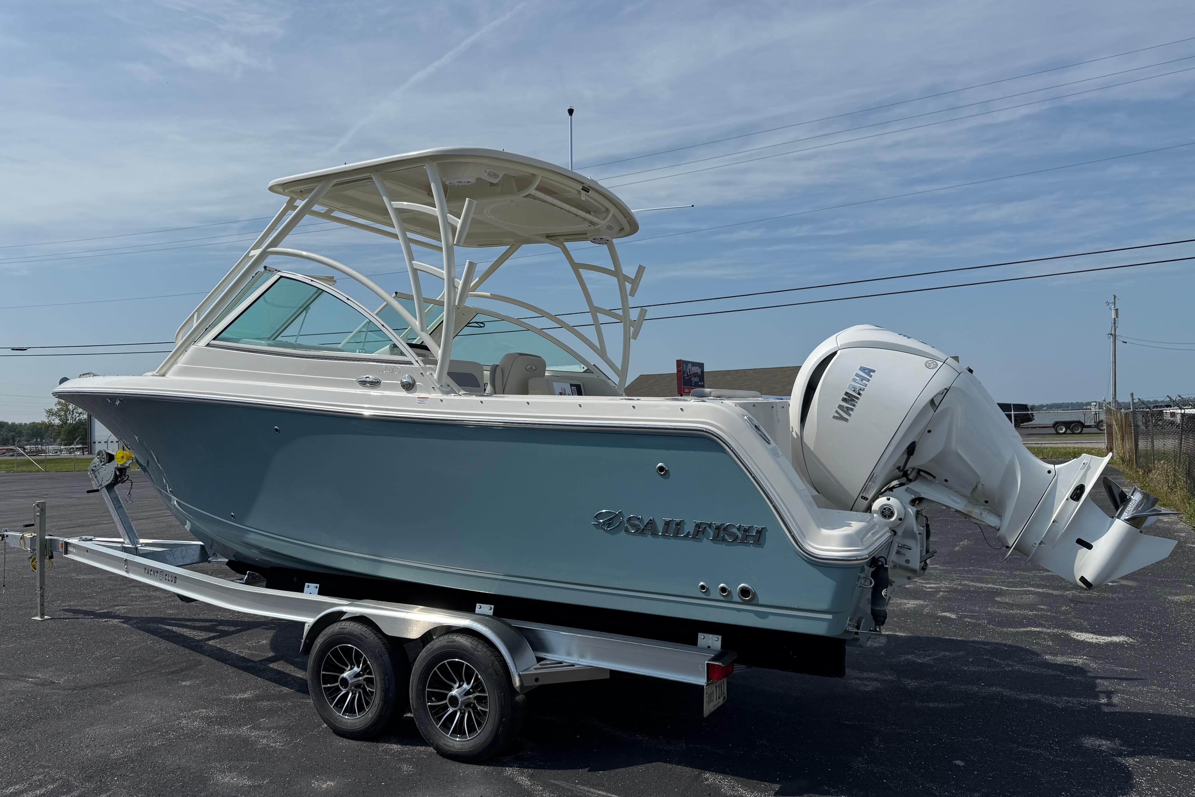 2025 Sailfish 245 DC boat on trailer with Yamaha outboard motor, parked outdoors.