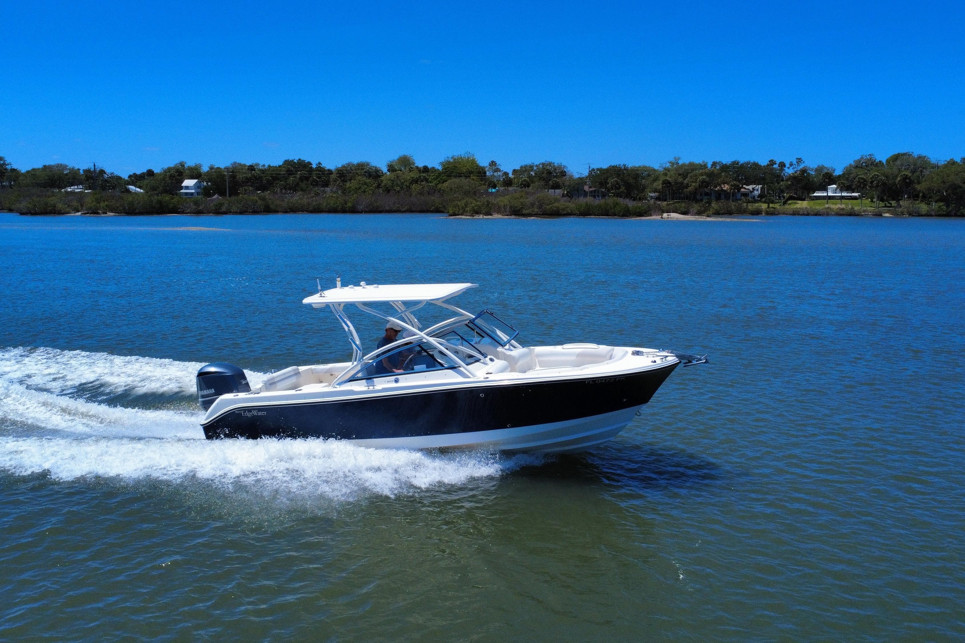 2012 Edgewater 245CX Crossover boat cruising on a sunny lake.