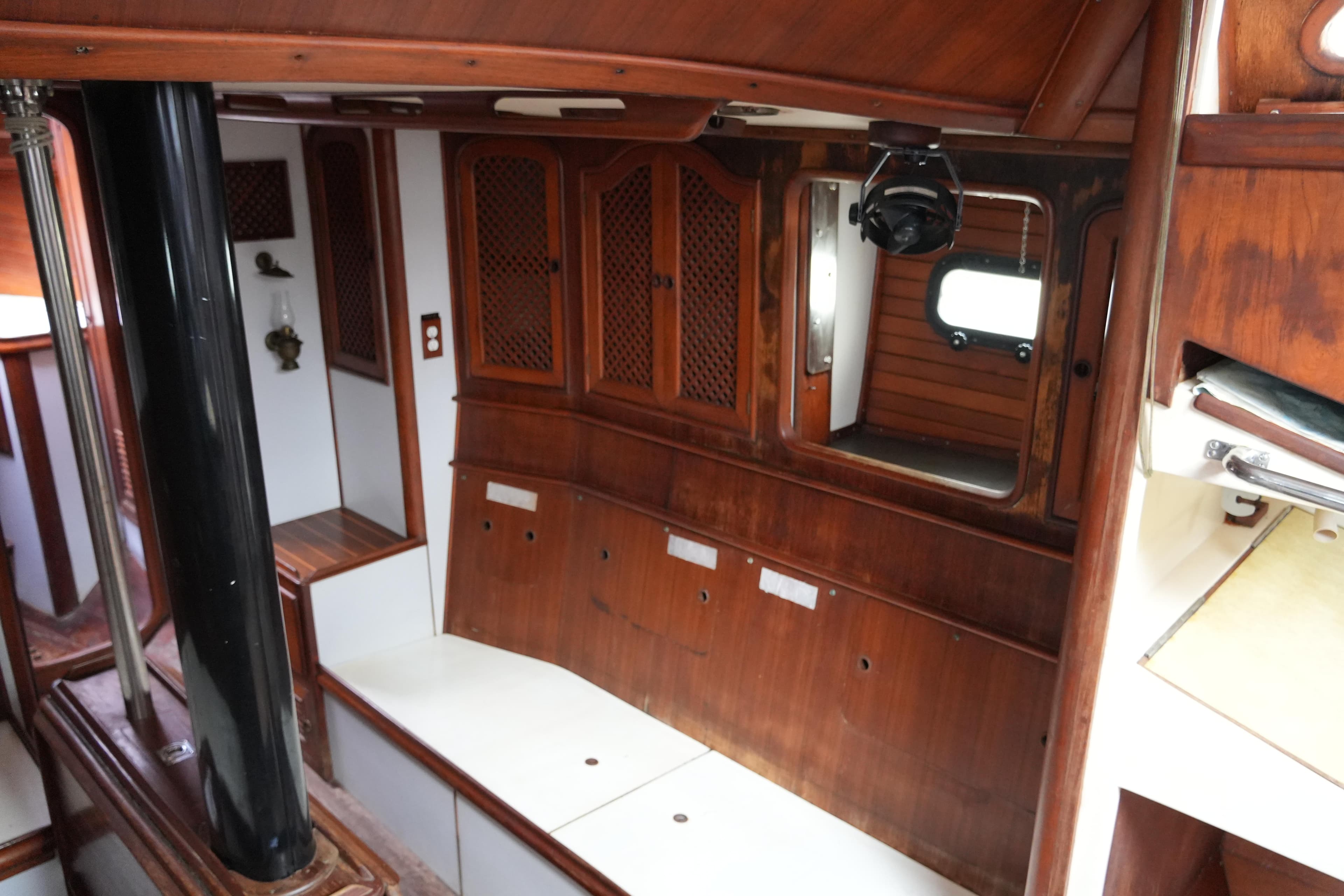 Interior of 1980 Lafitte 44 Cutter sailboat with wooden cabinetry and seating.