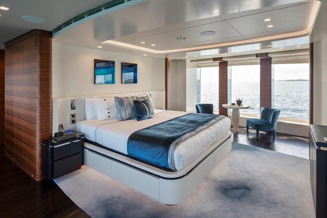 Luxurious Heesen 2021 yacht bedroom with ocean view, elegant decor, and modern furnishings.
