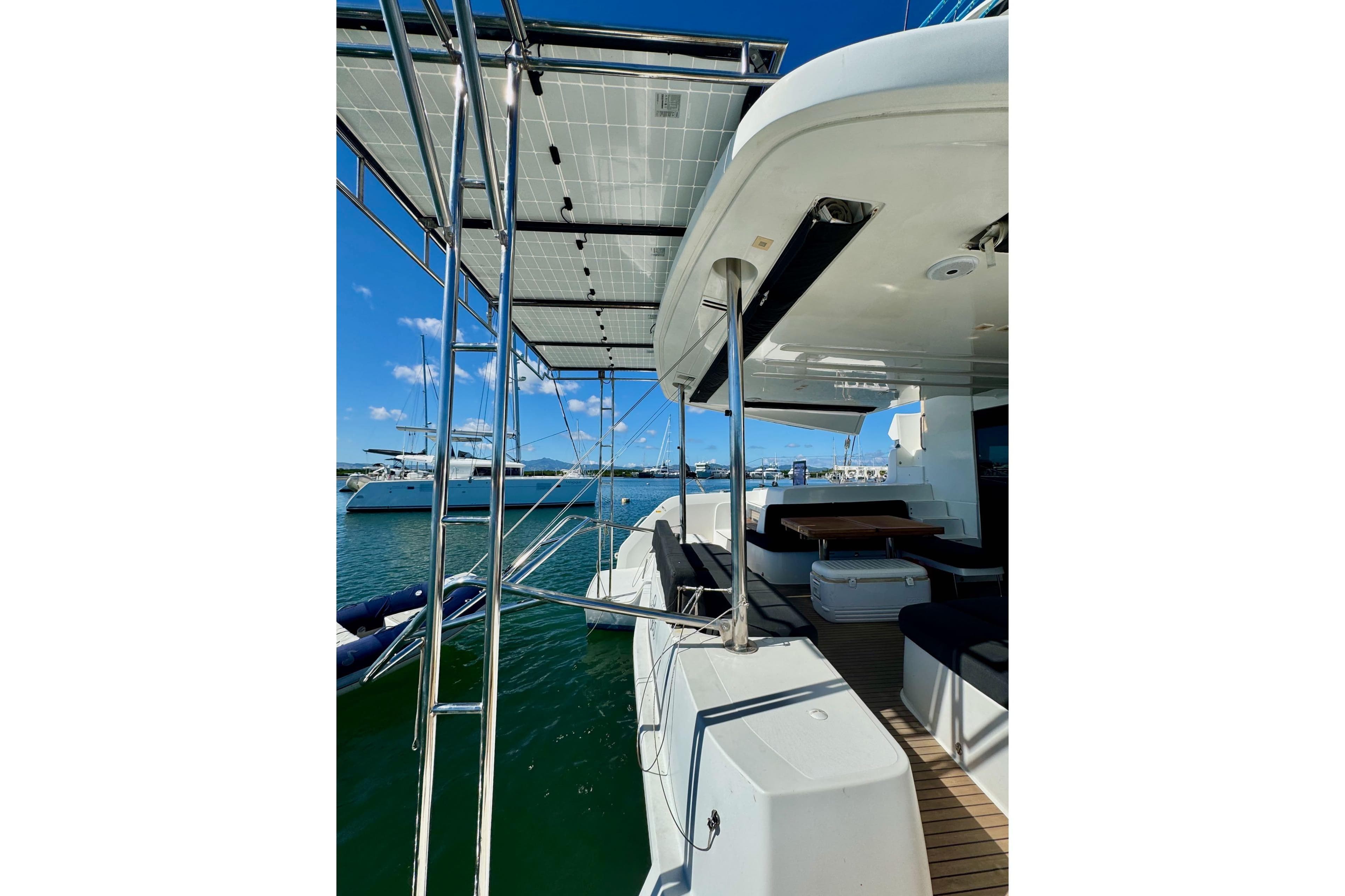 2018 Lagoon 50 catamaran with solar panels, docked in a sunny marina.