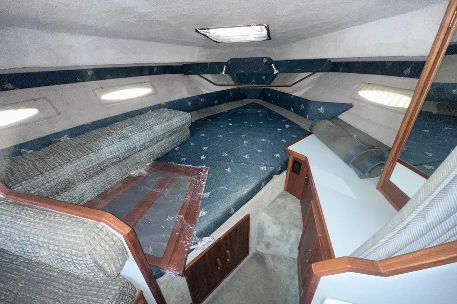 1987 Sea Ray 300 Sundancer cabin interior with blue upholstery and wooden accents.
