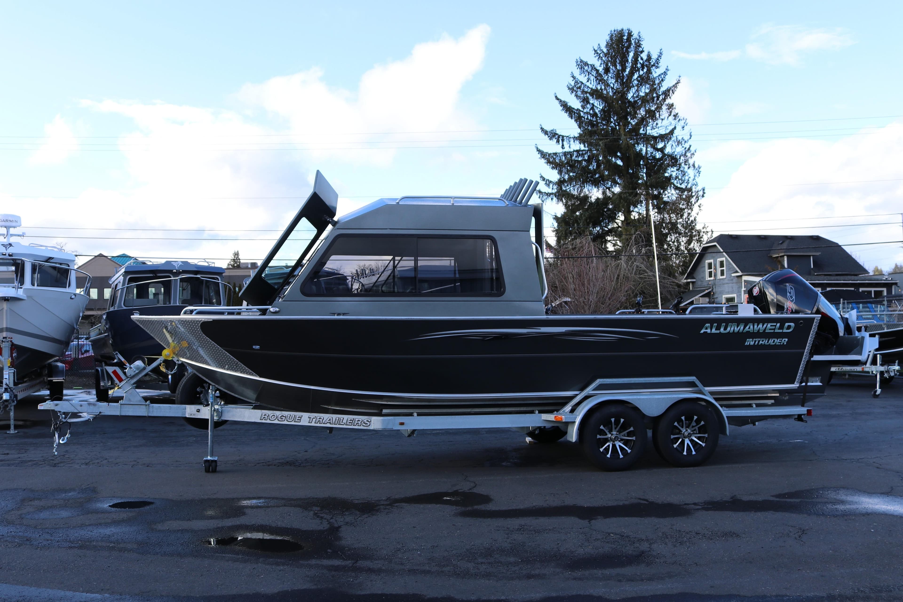 2026 Alumaweld Intruder Hard Top 24 boat on trailer, parked outdoors.