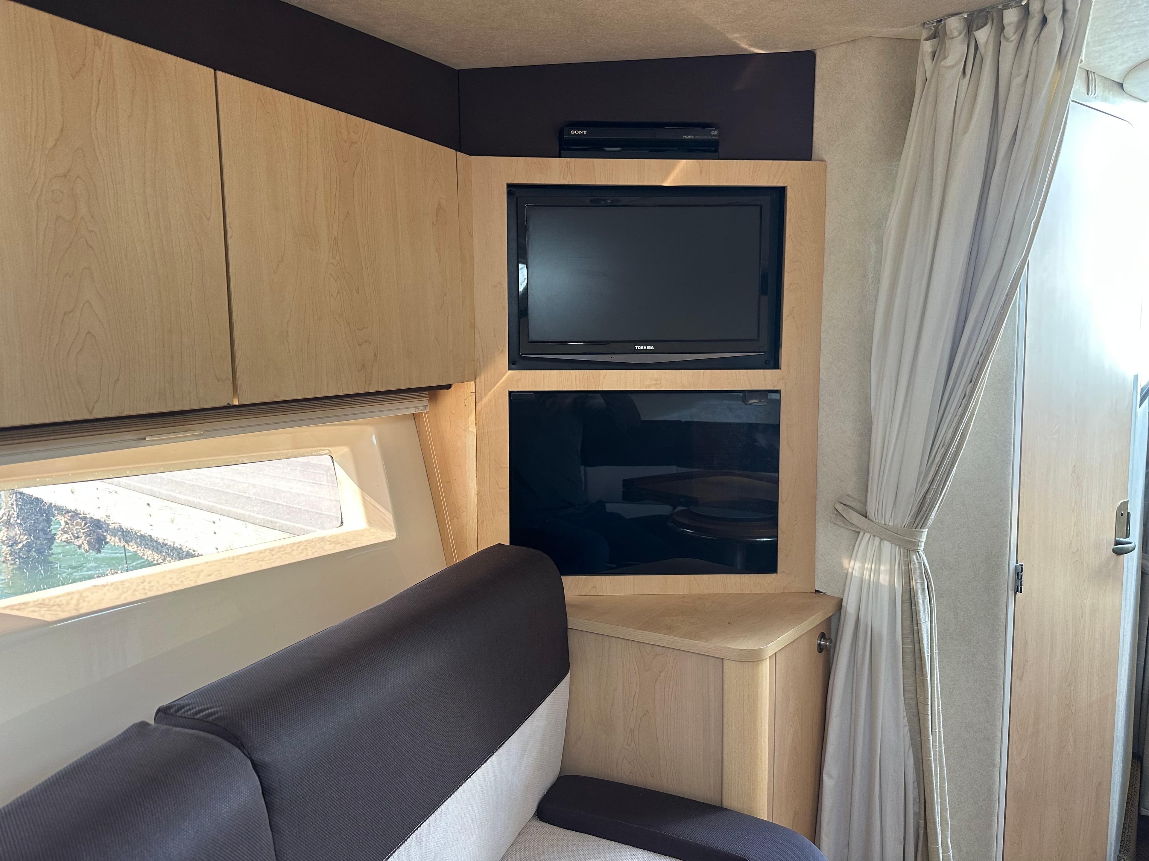 Interior of 2013 Sea Ray 370 Venture with TV and modern cabinetry.