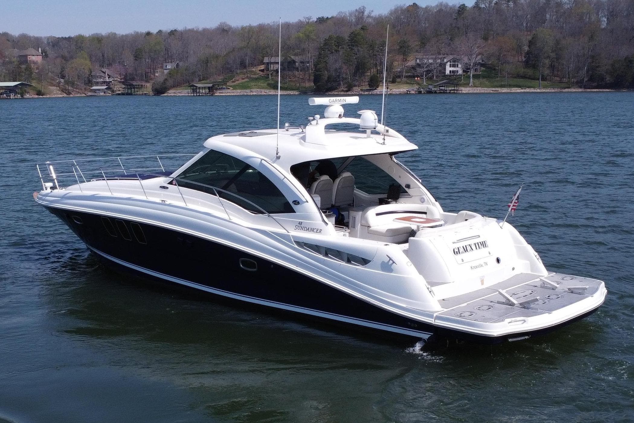 2006 Sea Ray 48 Sundancer yacht on a serene lake with wooded shoreline.