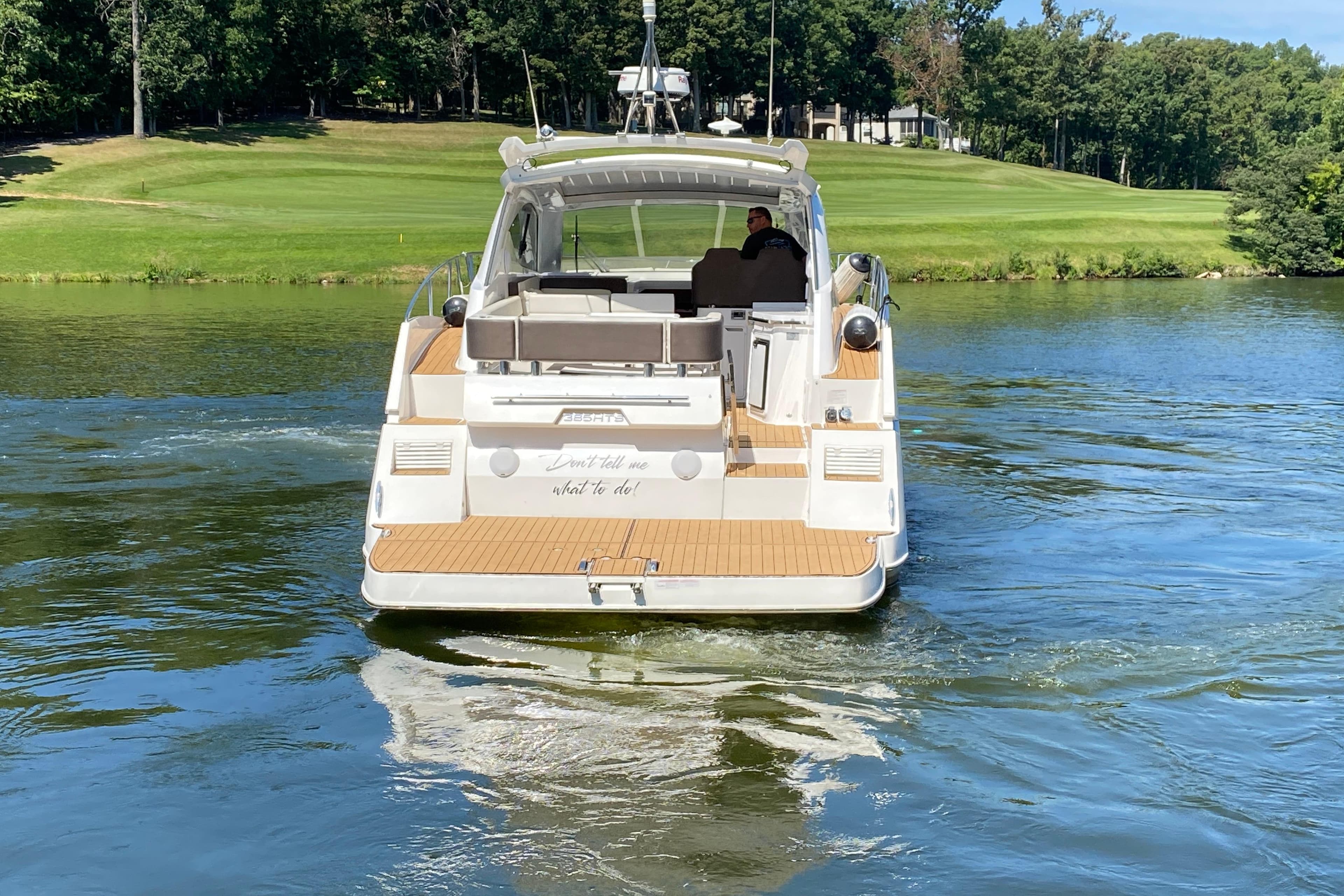 2018 Galeon 385 HTS yacht cruising on a serene lake with lush greenery.