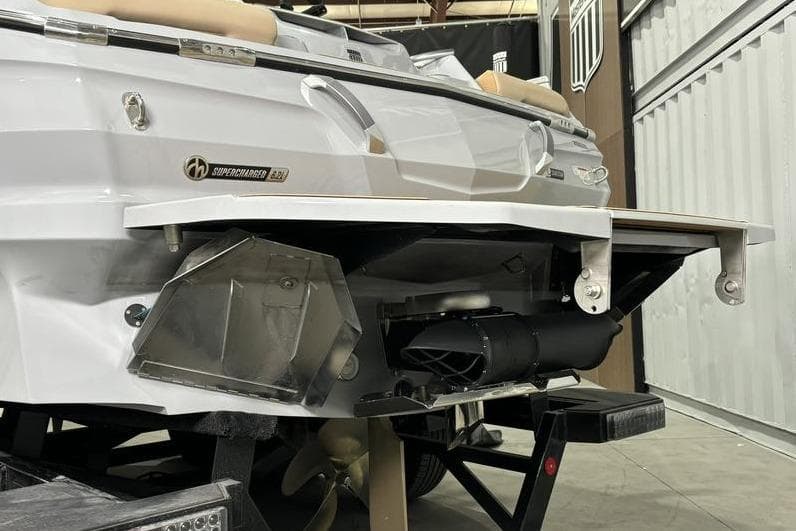 2024 MasterCraft X24 boat rear view with supercharged engine detail in a garage setting.