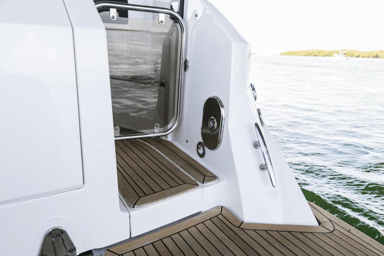2024 Sea Ray Sundancer 320 Outboard boat deck with teak flooring and water view.