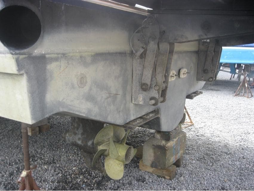 2011 Sea Ray 540 Sundancer boat propeller and hull on gravel.