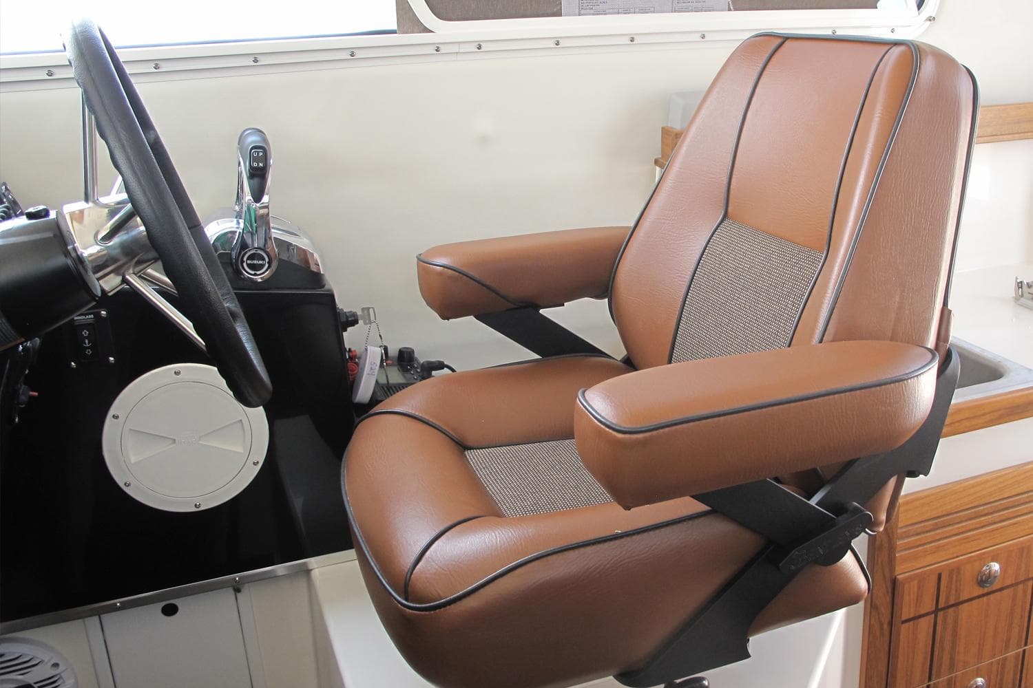 Captain's chair in 2026 SeaSport Kodiak 2600 boat, featuring brown leather upholstery.