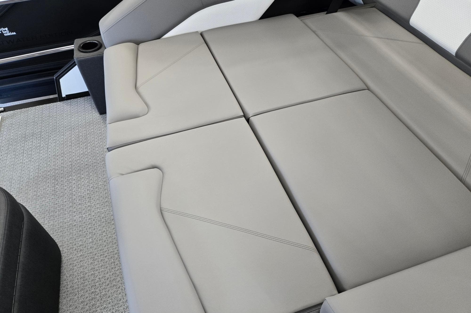 2026 Evotti 521CS boat interior with sleek, modern seating and carpeted flooring.