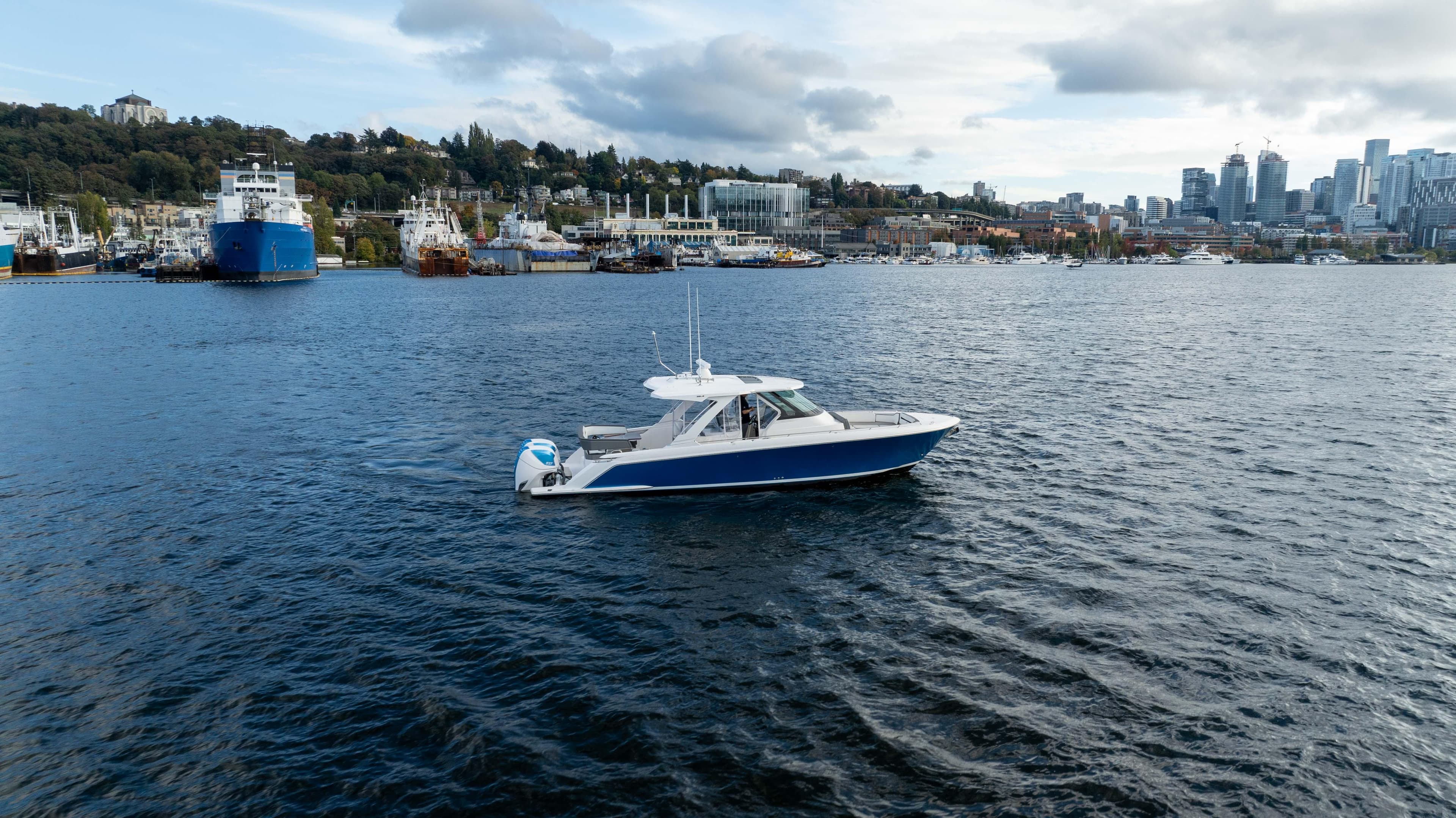 2020 Tiara Sport 38 LS boat on a scenic waterfront with city skyline.