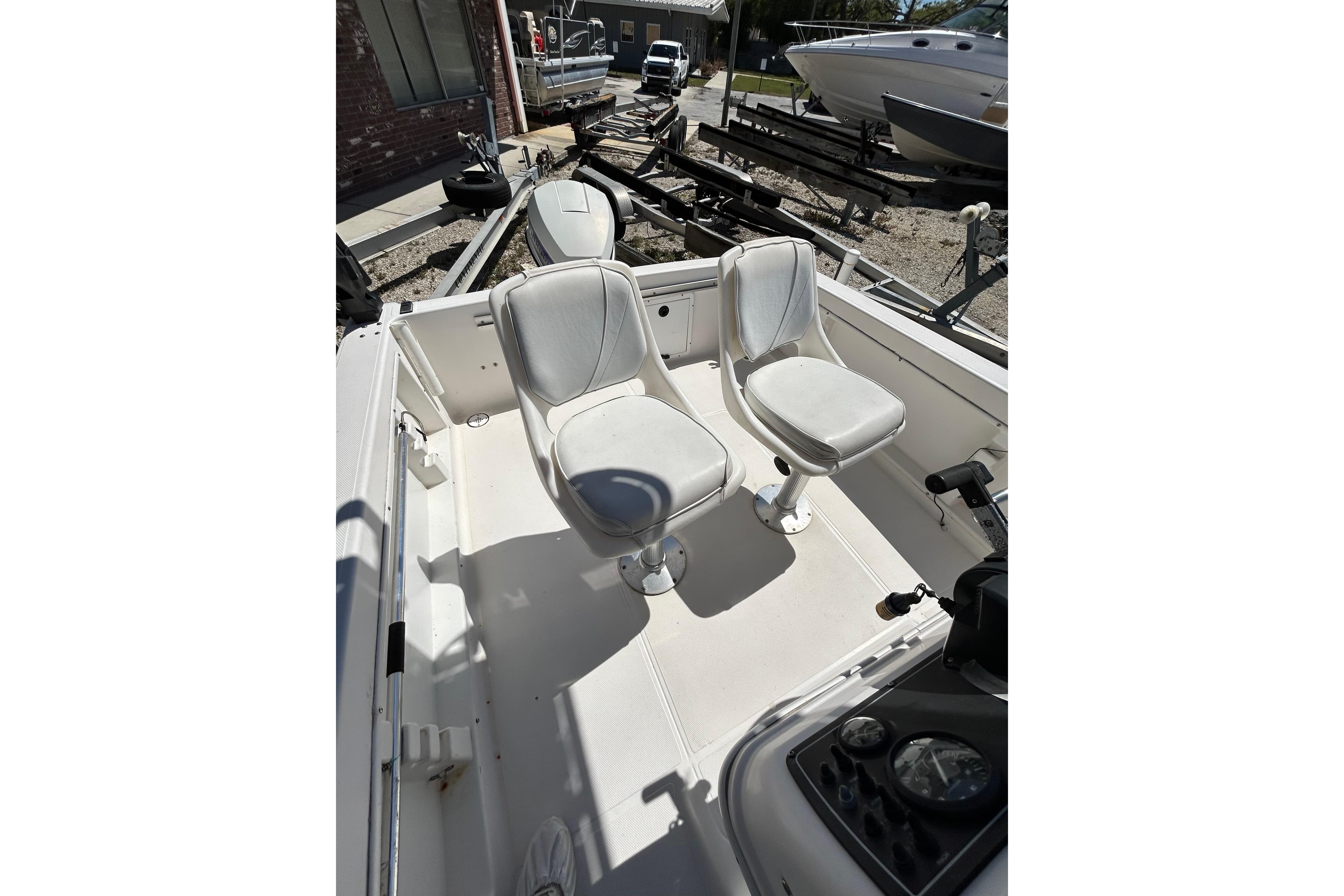 1996 Wellcraft 190 CCF boat interior with two white seats and control panel.