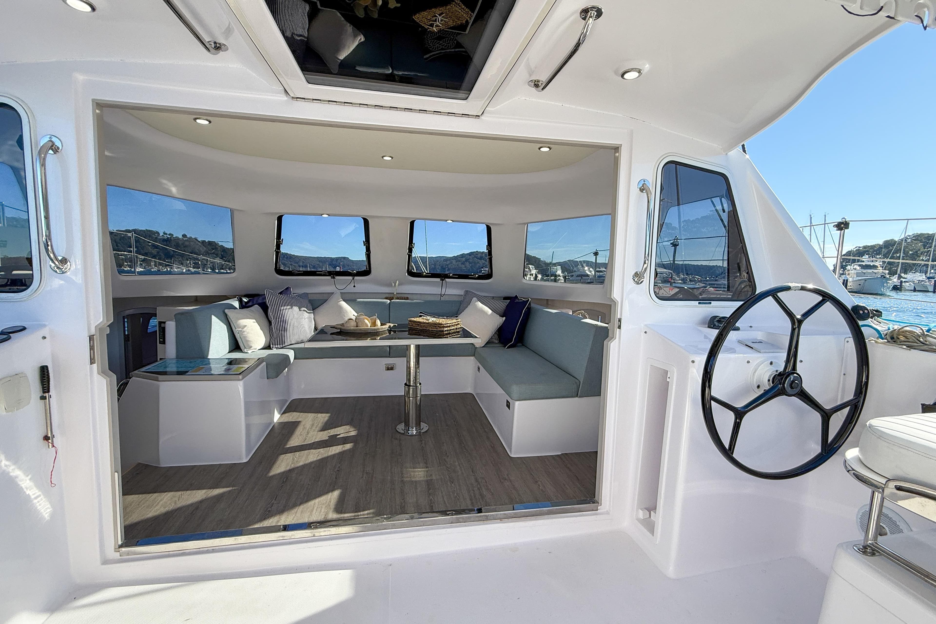 Interior of 2019 Seawind 1190 catamaran with spacious seating and helm, docked at marina.