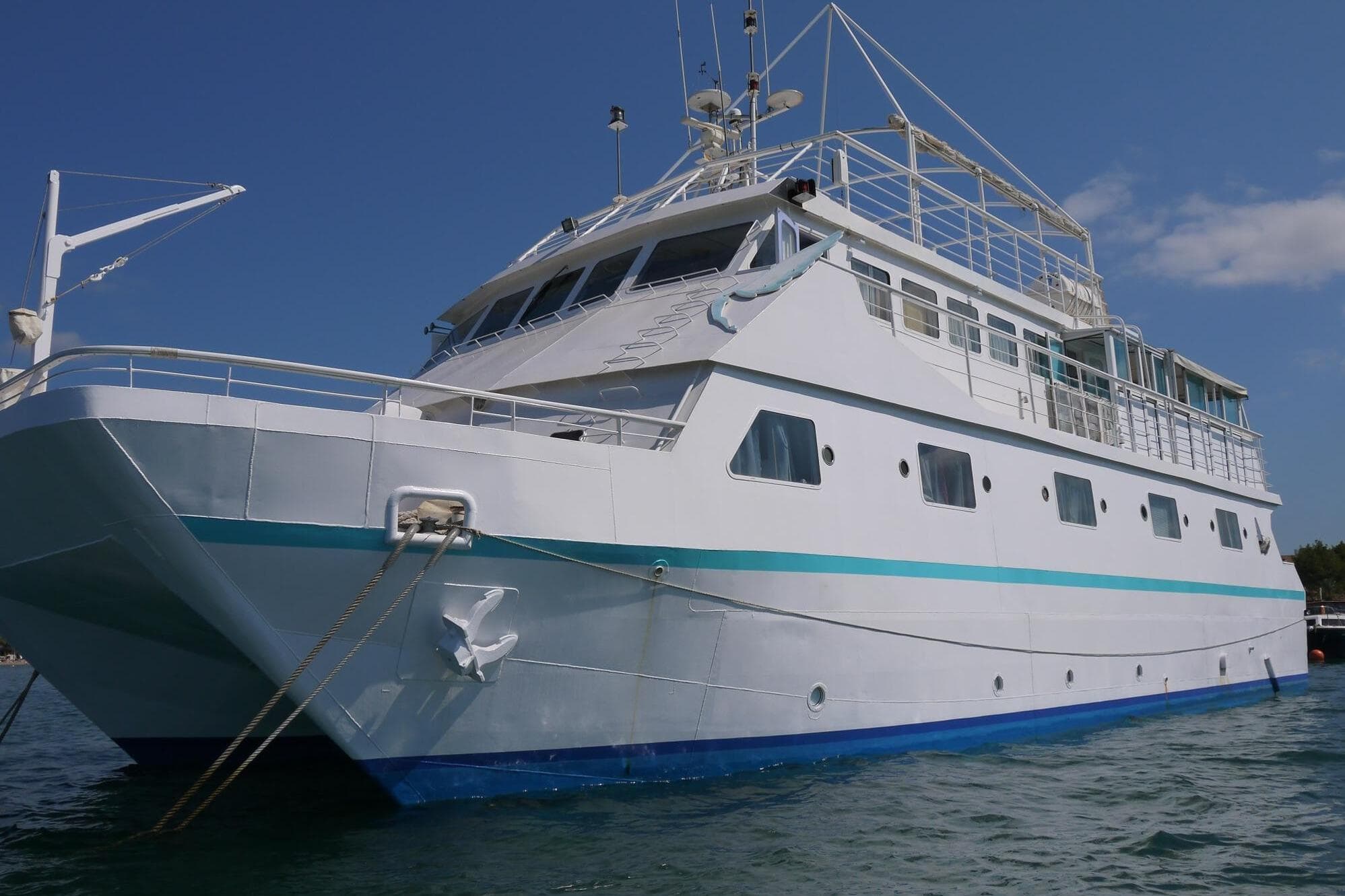 1988 Poseidon motor catamaran on water, showcasing sleek design and spacious deck.