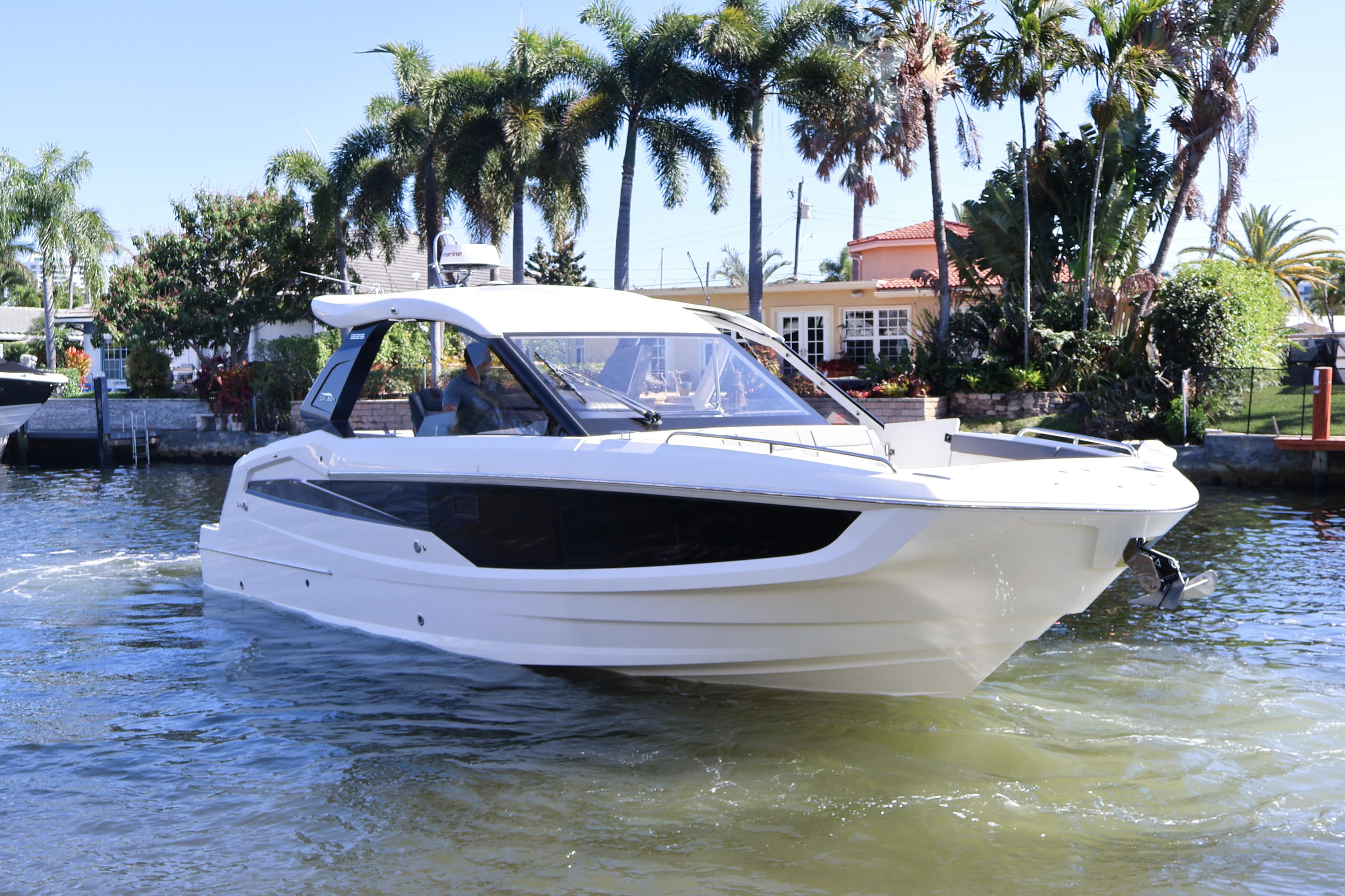 2024 Galeon 325 GTO luxury yacht cruising on a sunny day near palm trees.