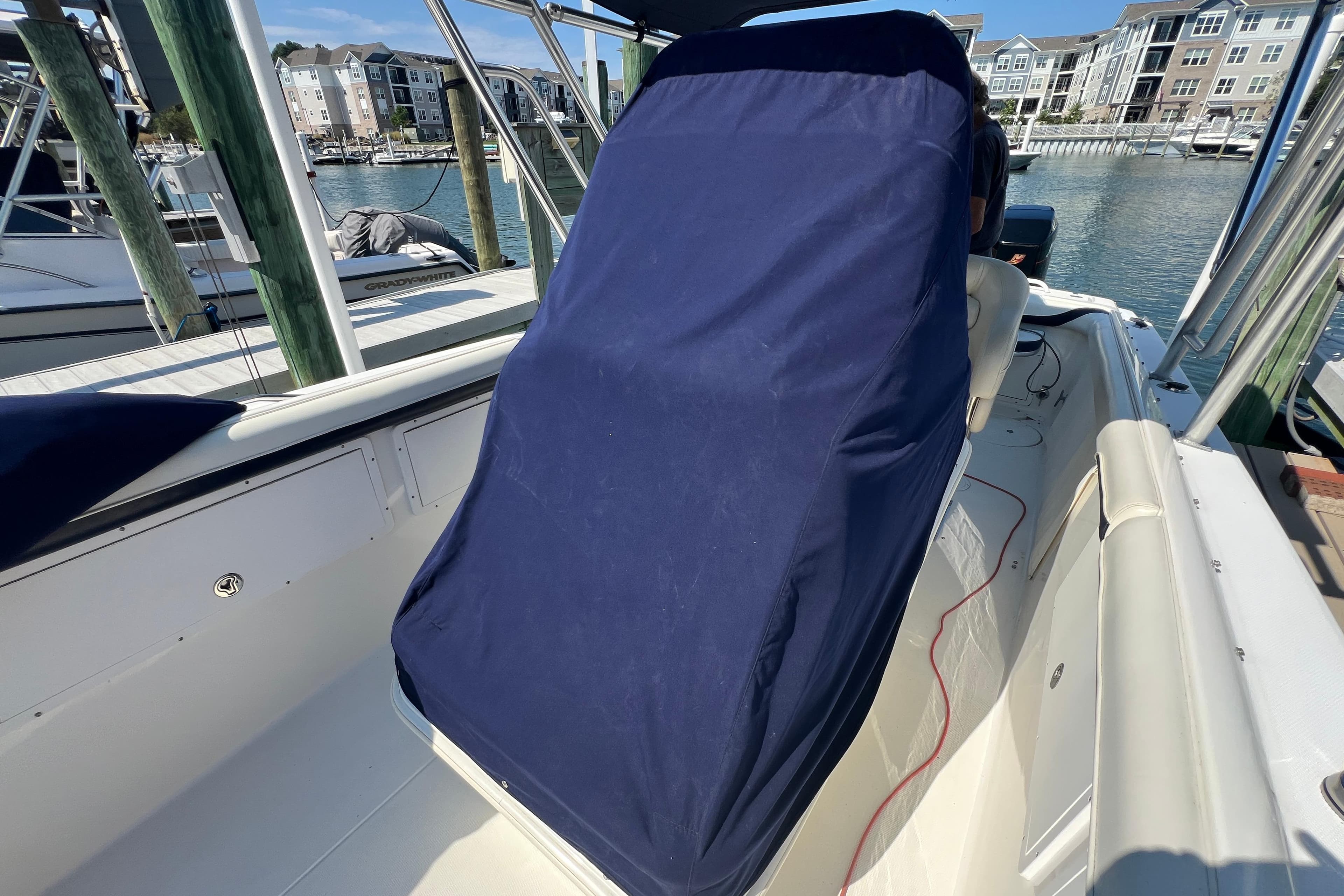 1999 Wellcraft 302 Scarab Sport boat with covered seating, docked in a marina.