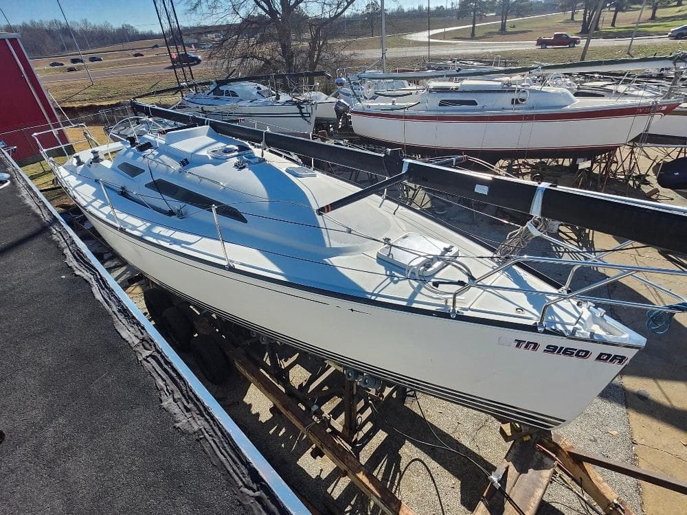 Sailboat C&C 99, 2002 model, docked in a marina under clear skies.