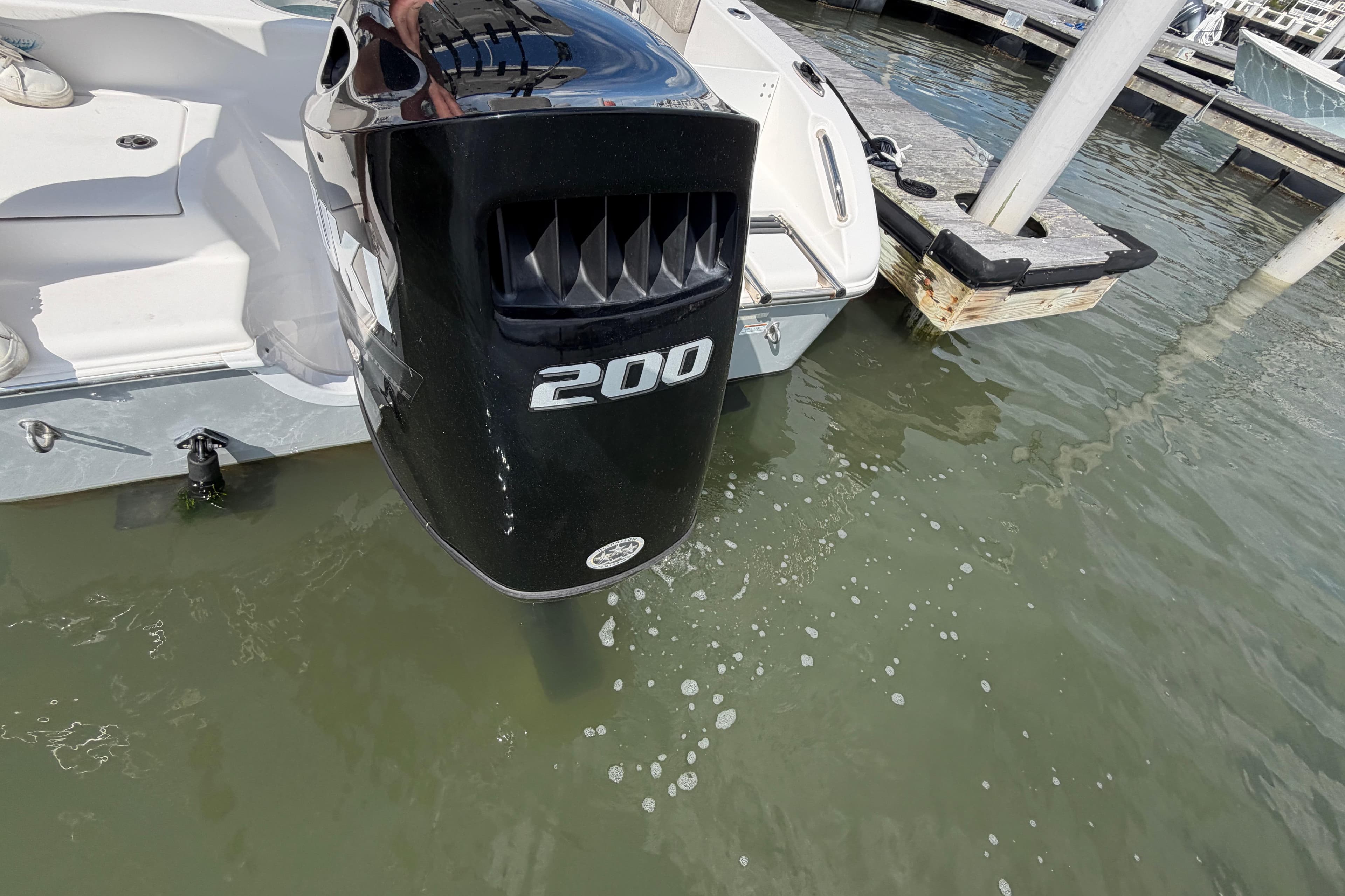 Outboard motor on 2022 Sea Pro 219 Deep V CC boat docked in marina.