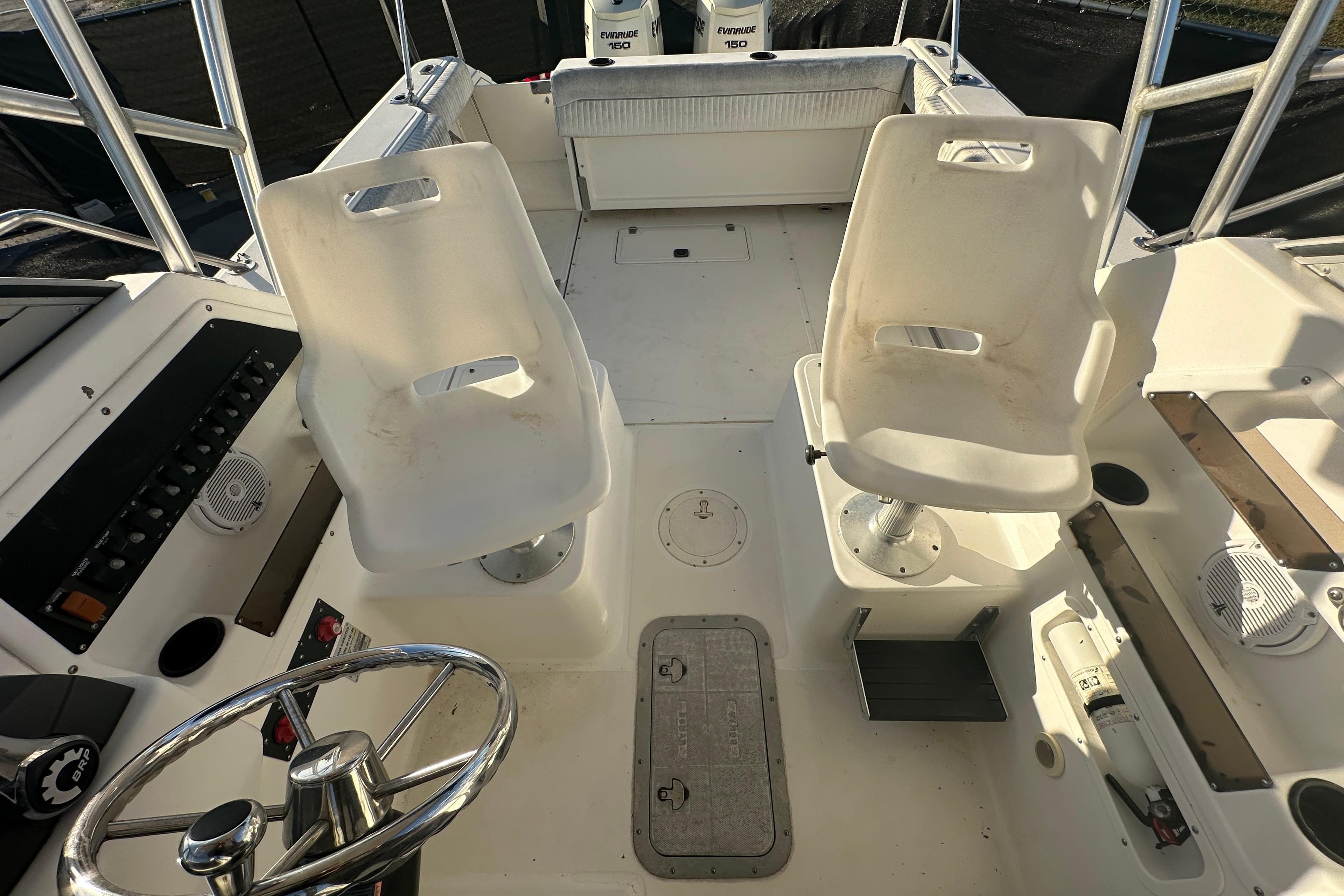 2001 Boston Whaler 23 Conquest boat interior with steering wheel and seating area.