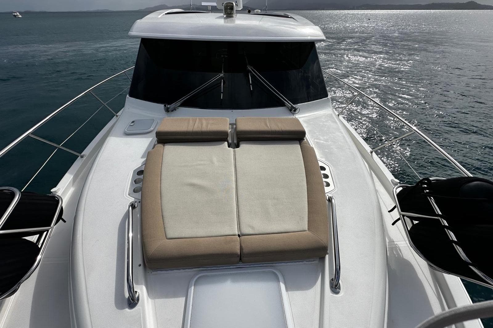 2020 Riviera 395 SUV yacht with sunbed on deck, cruising on calm waters.