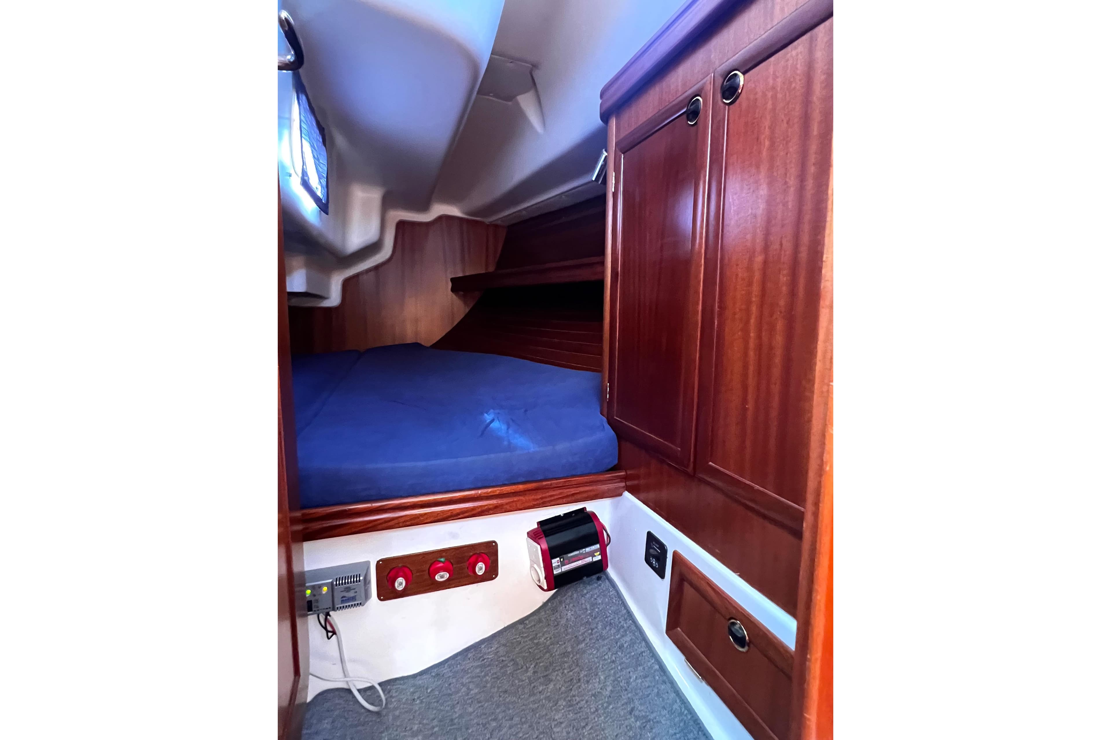 2004 Adria Event 34 yacht cabin with wooden interior and blue bedding.