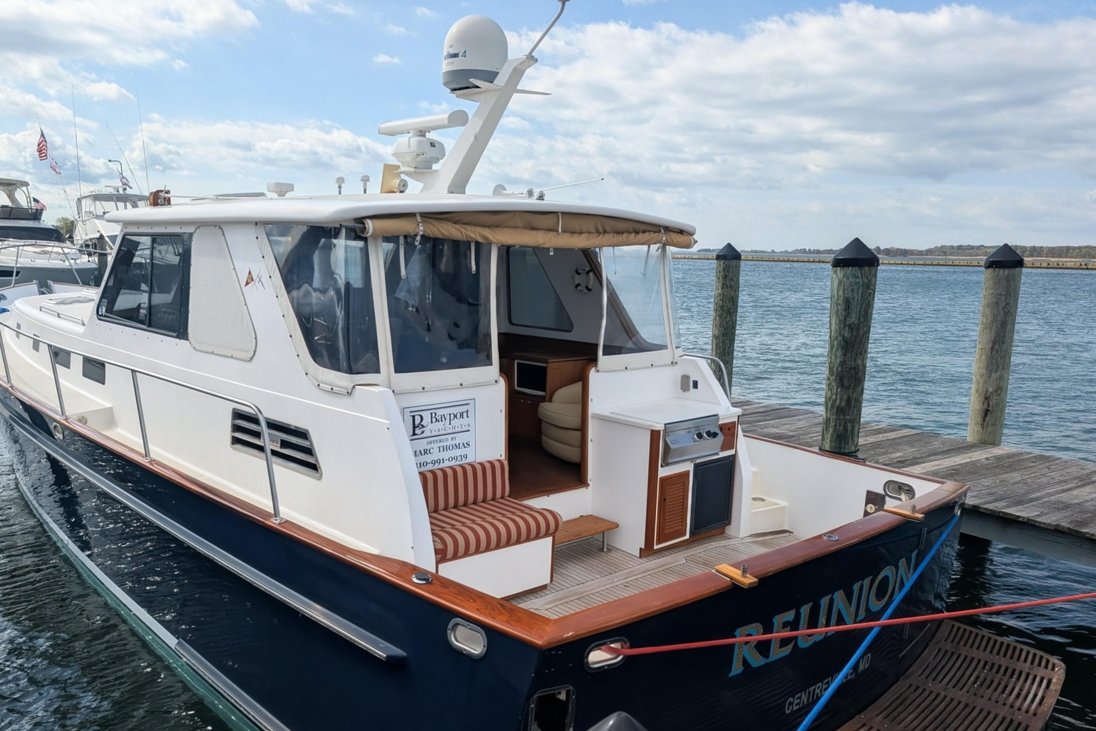 2002 Legacy Yachts 52 Express docked, featuring spacious deck and elegant design.