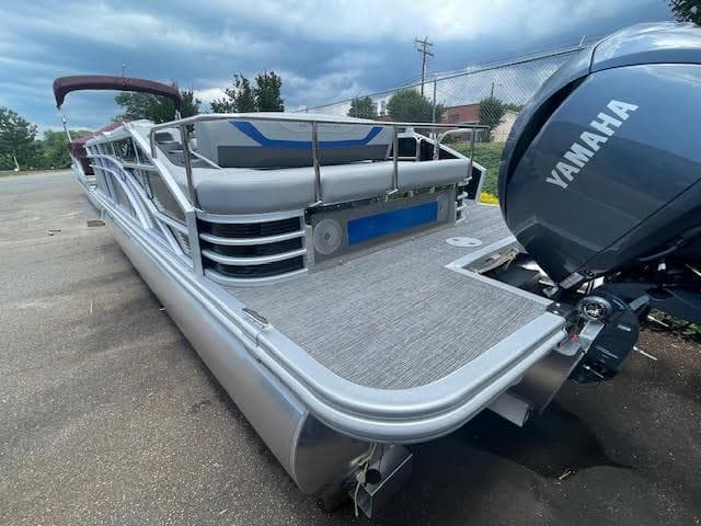 2024 Bennington 22SXSWB pontoon boat with Yamaha engine, parked outdoors.