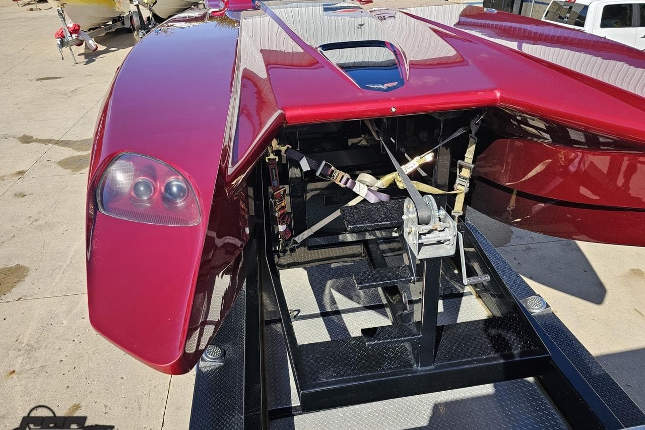 Red 2010 MTI 44 Corvette boat on trailer, showcasing sleek design and rear view.