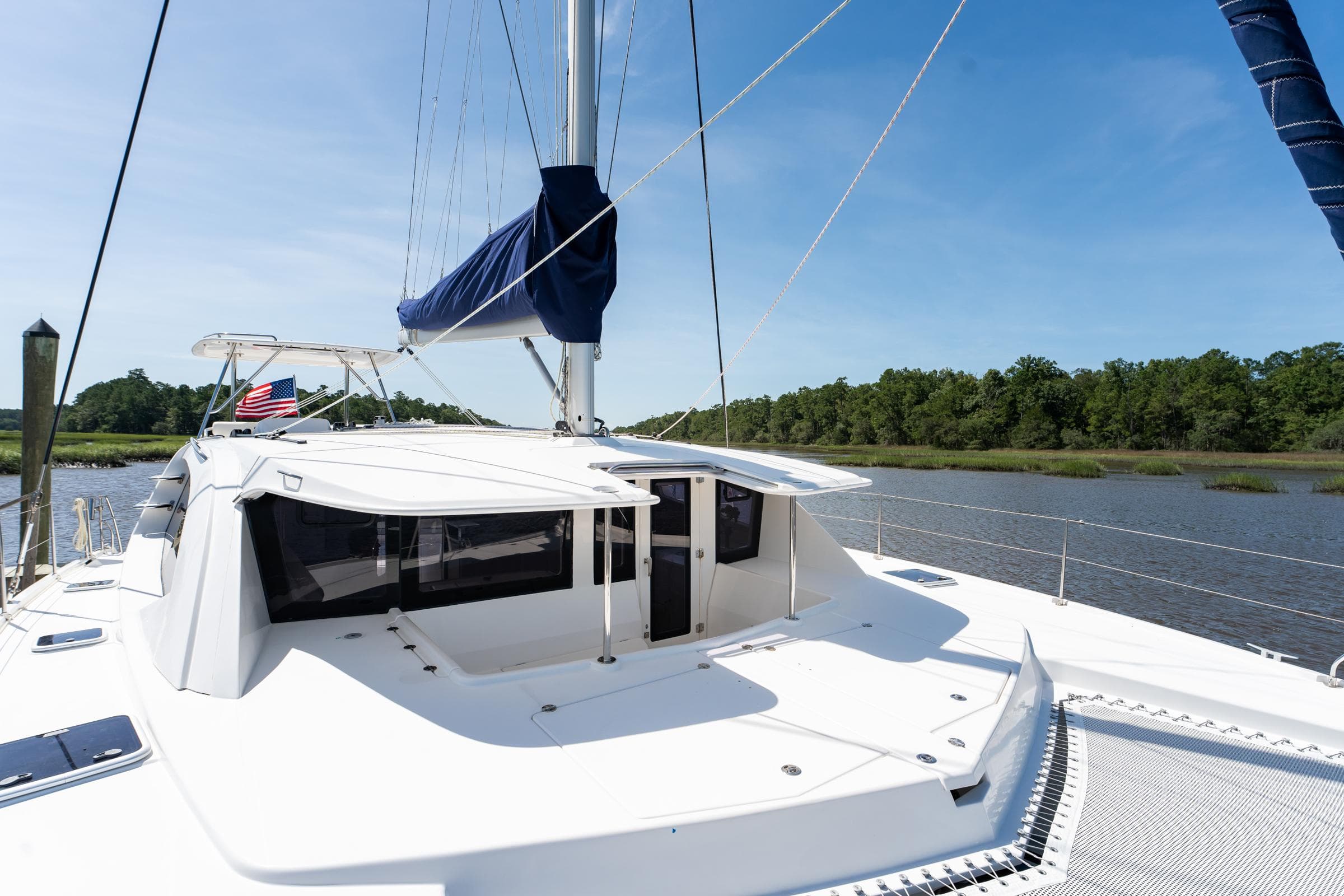 2016 Leopard 44 Owners Version catamaran on a serene river with lush greenery.