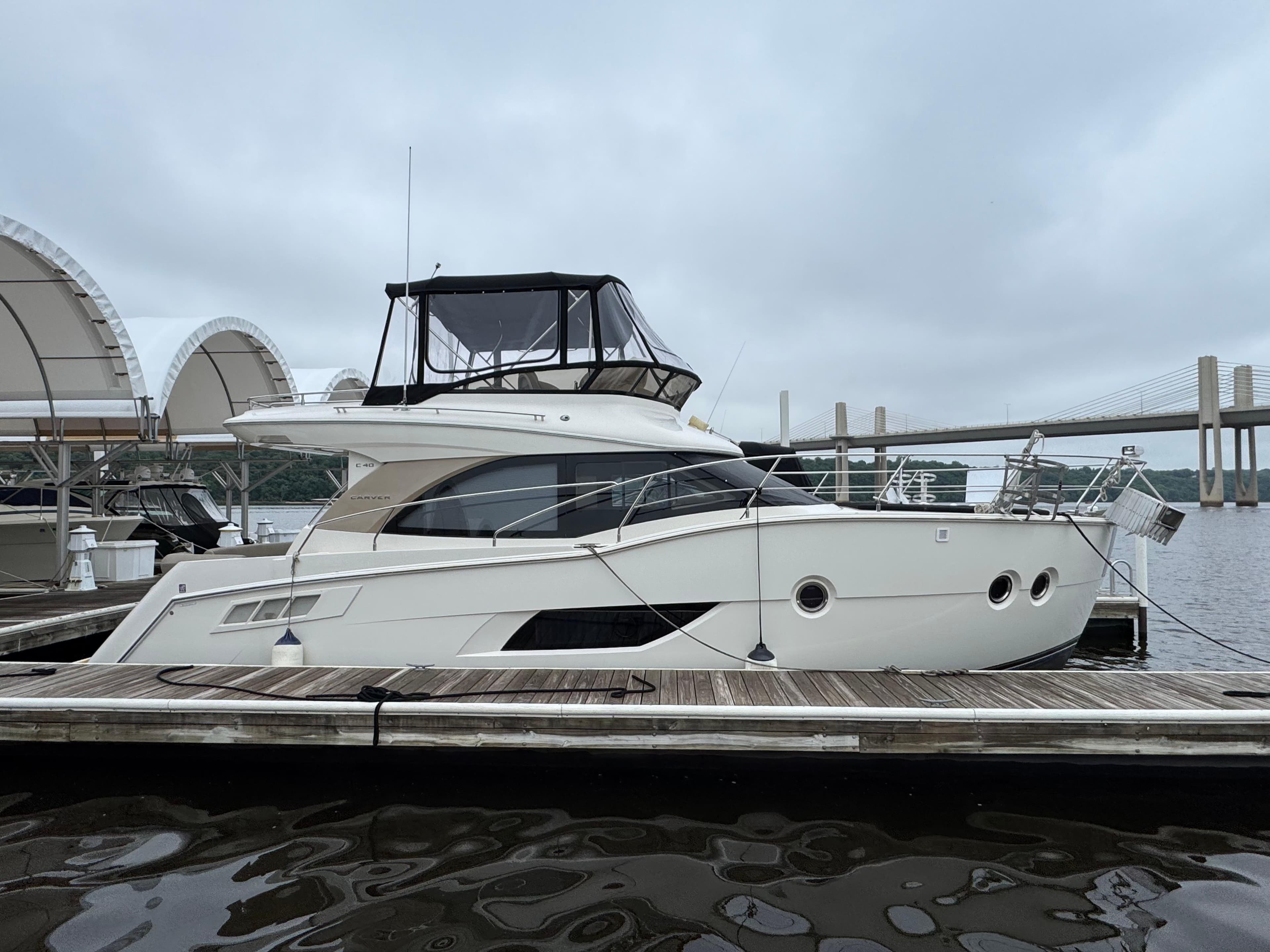 2014 Carver C40 Command Bridge yacht docked at marina with bridge in background.