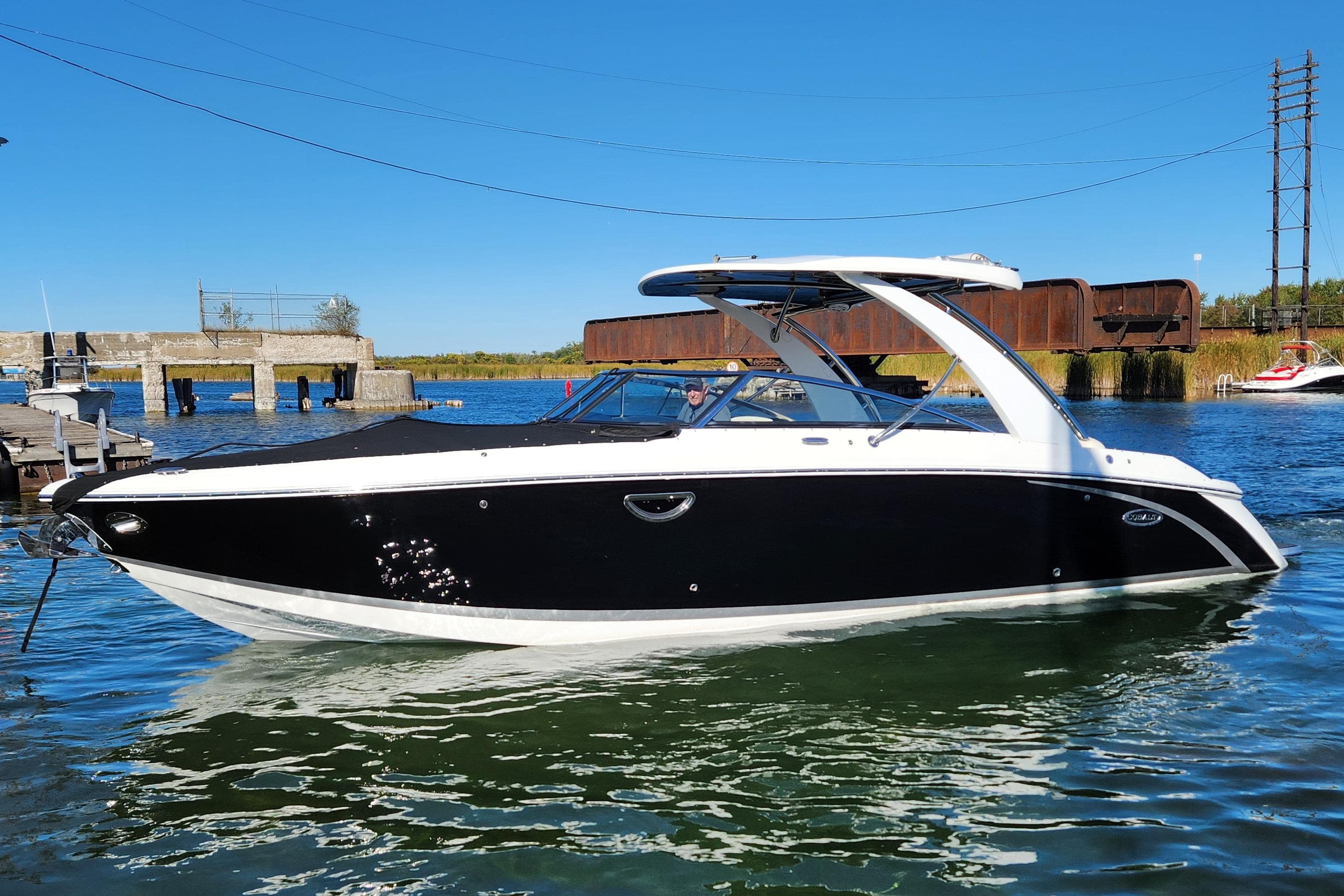 2017 Cobalt R30 boat on water, sleek black and white design, clear blue sky.