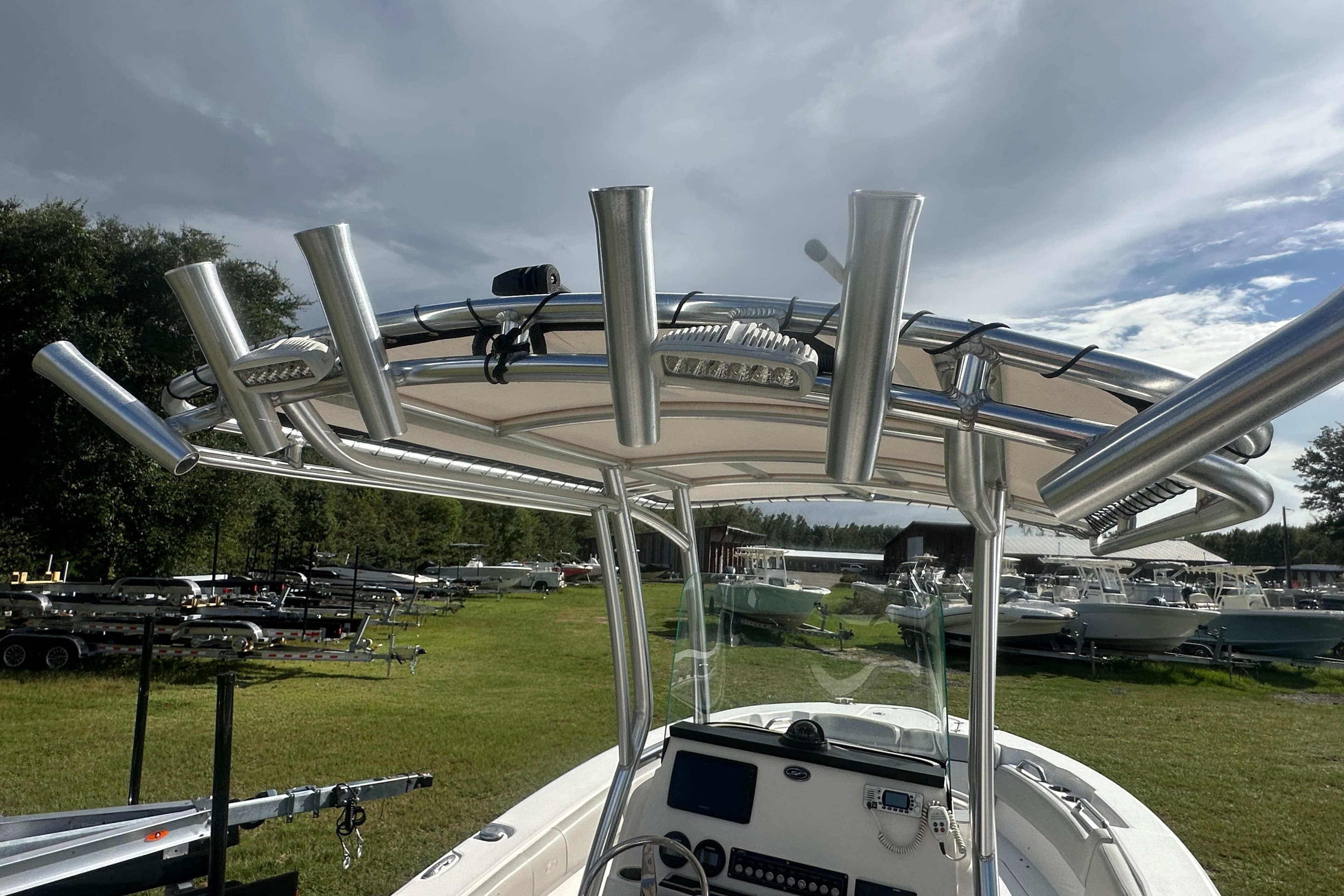 2023 Sea Fox 228 Commander boat with T-top and rod holders, parked outdoors.