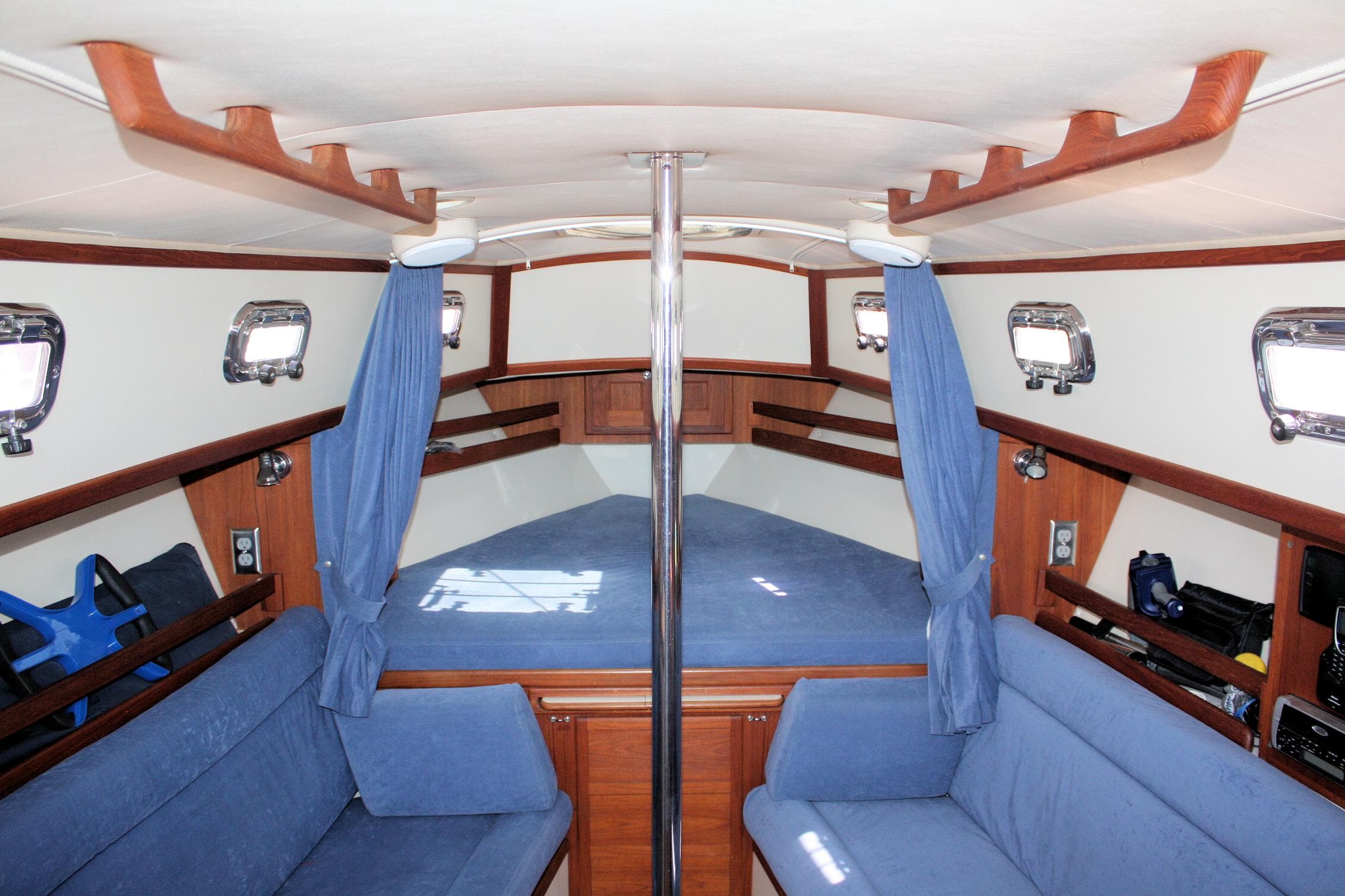 Interior of 2004 Pacific Seacraft 31 sailboat with blue upholstery and wooden accents.