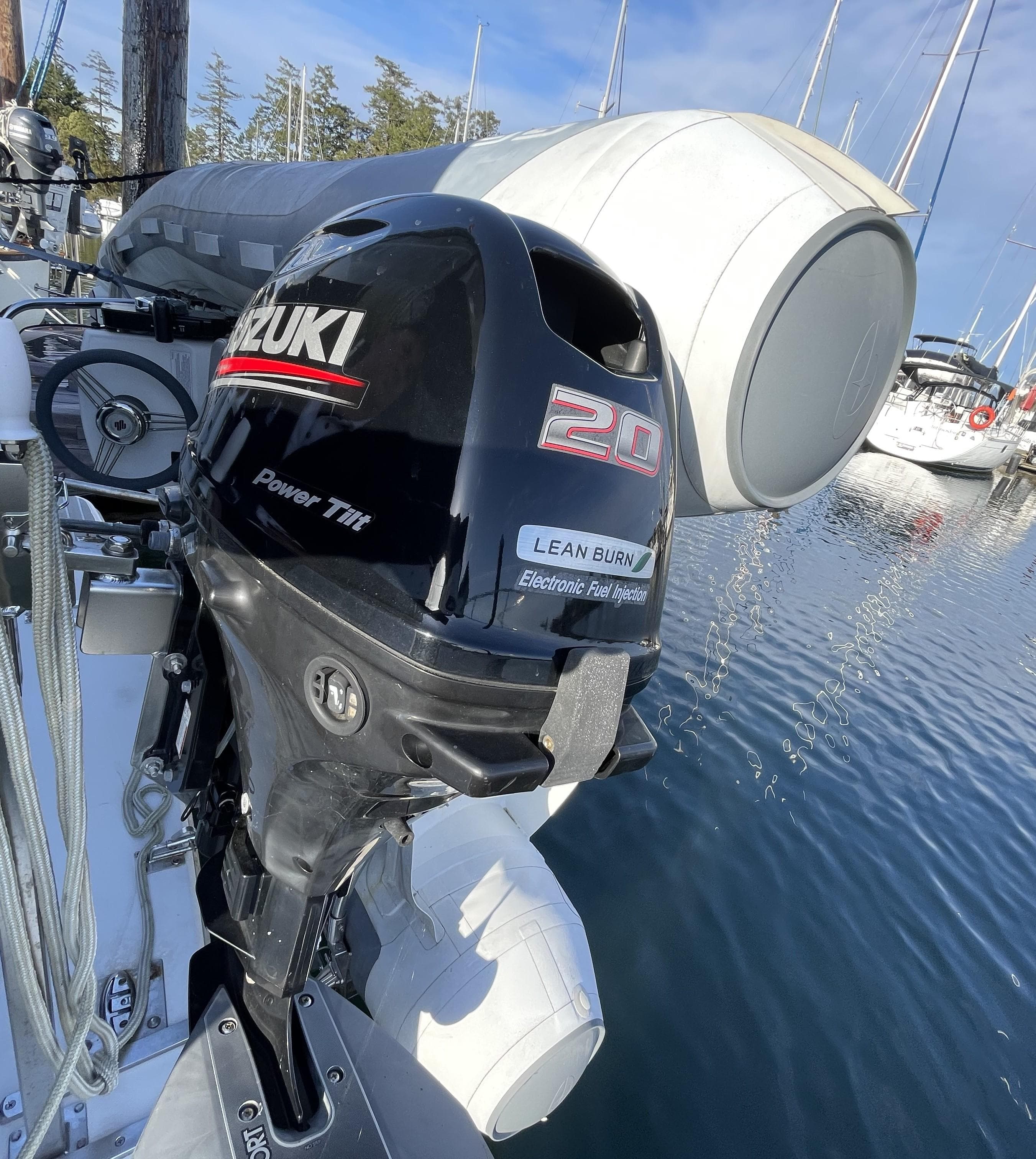 Suzuki 20 HP outboard motor on a 1991 Bayliner 4387 yacht at a marina.