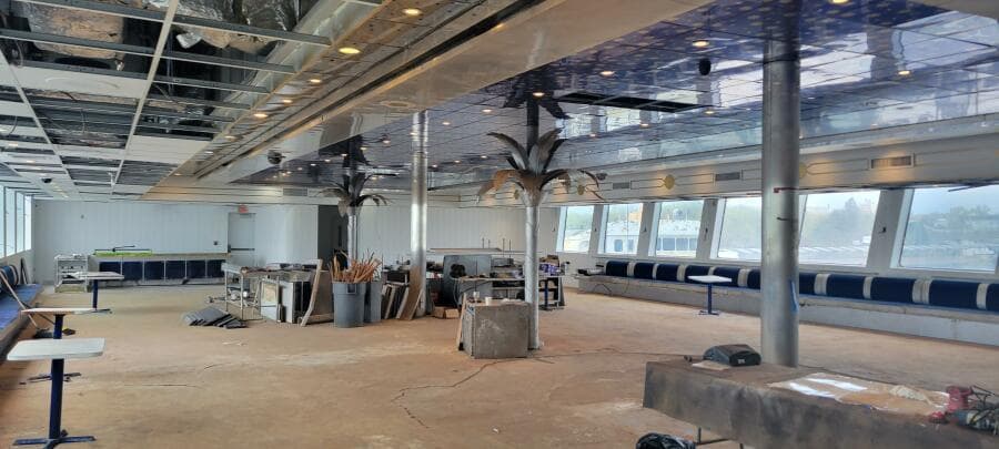 Spacious interior of 1981 Custom Victory 11 ship under renovation, featuring large windows and ceiling lights.