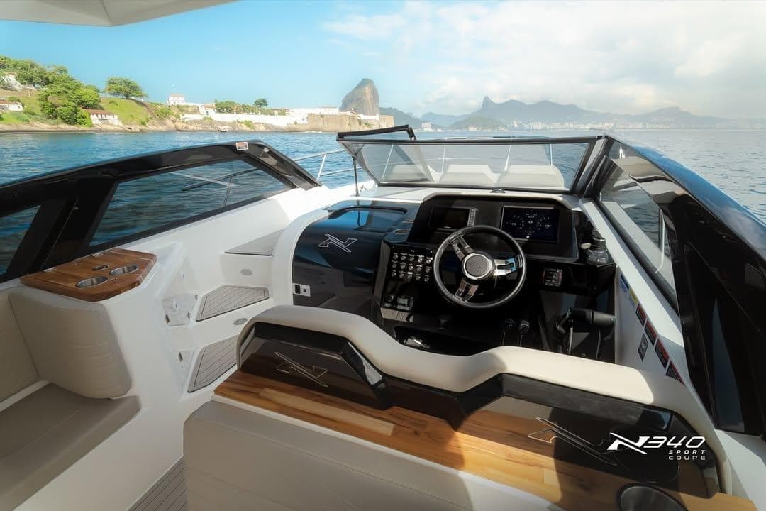 2026 NX Boats NX340 cockpit with modern controls, luxurious seating, and scenic ocean view.