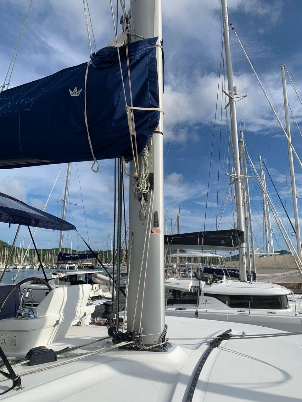 2018 Lagoon 50 catamaran docked at marina under clear blue sky.