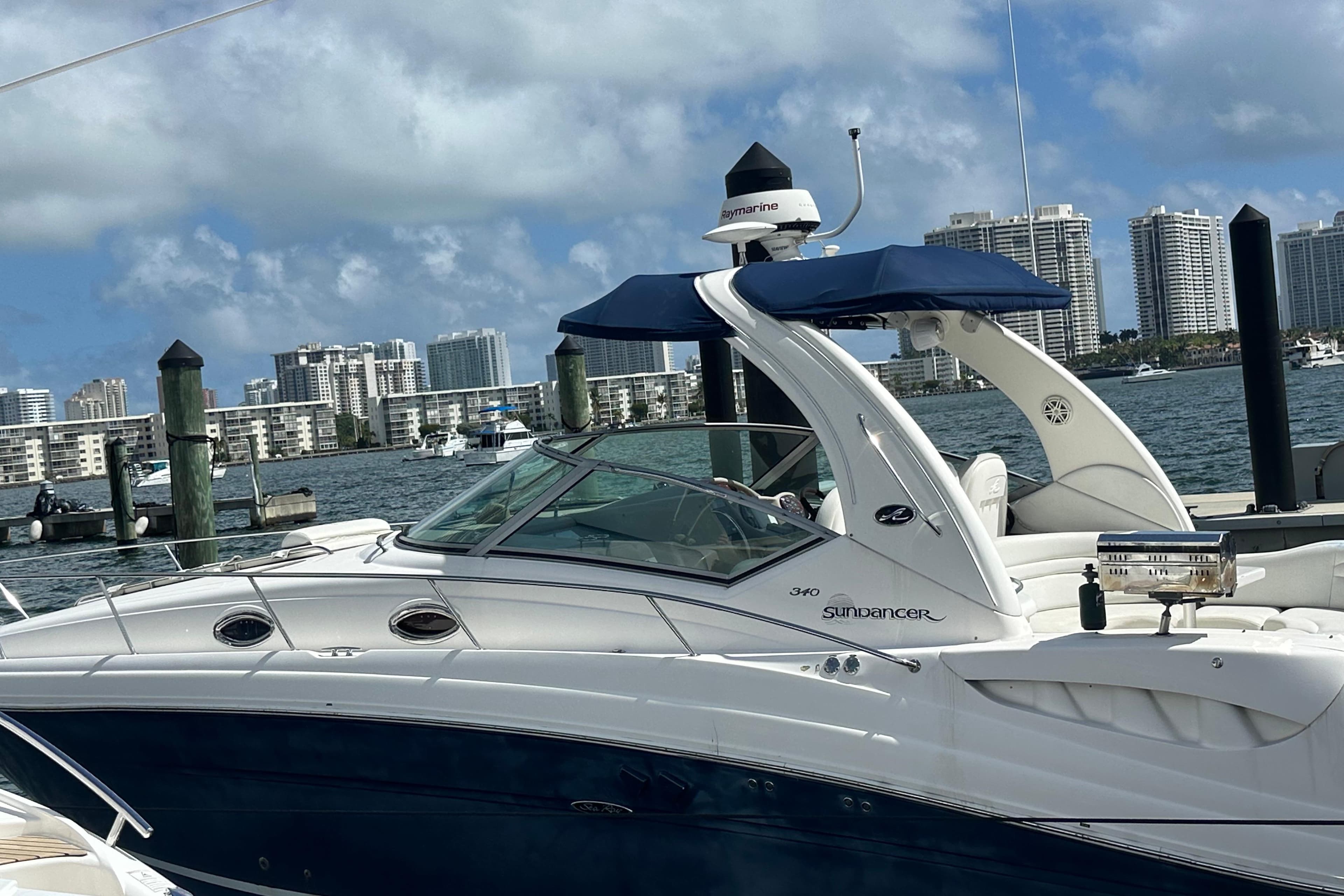 2008 Sea Ray 340 Sundancer yacht docked with city skyline in background.