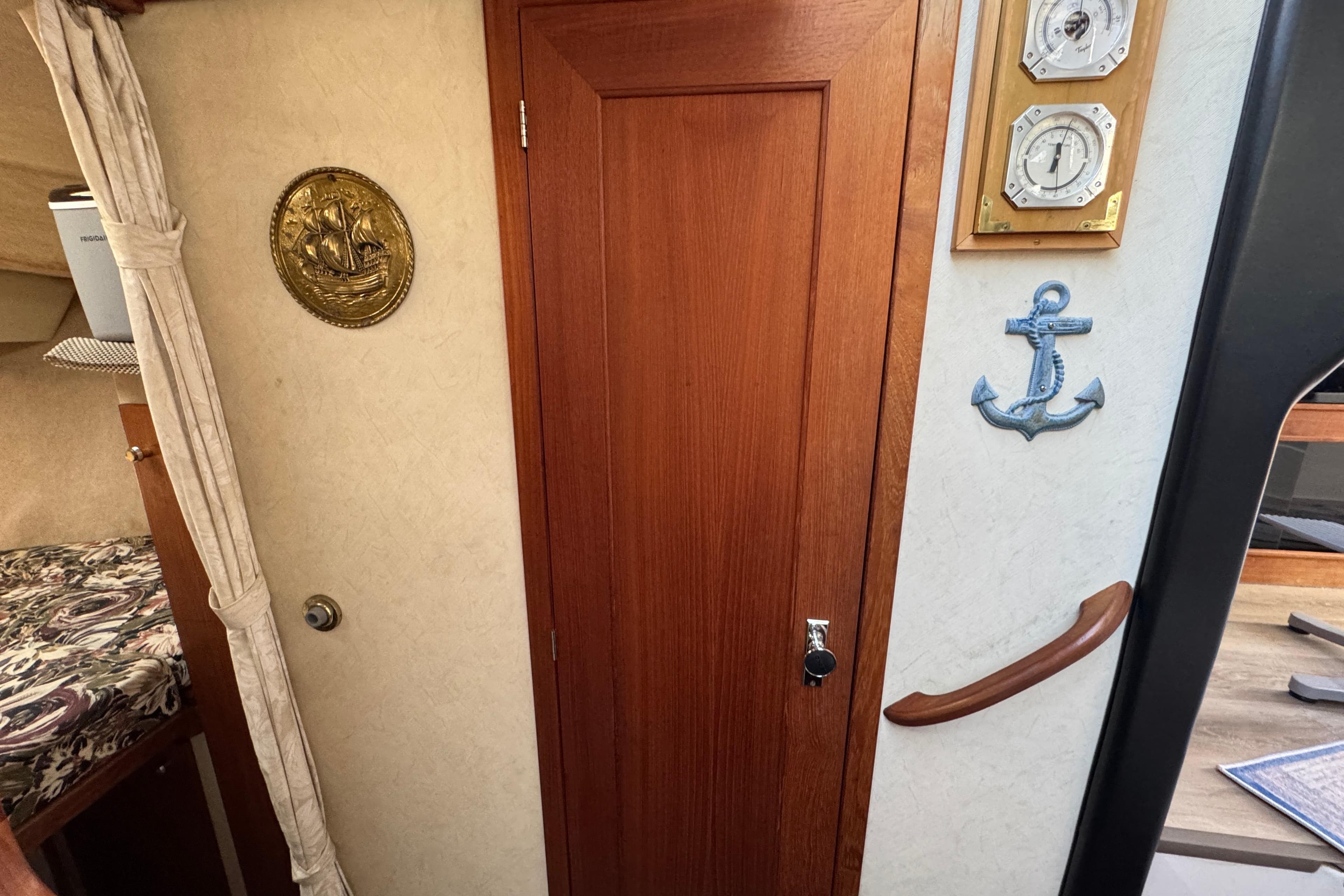 Interior of 1995 Bayliner 3288 Motoryacht with wooden door, nautical decor, and cozy cabin.