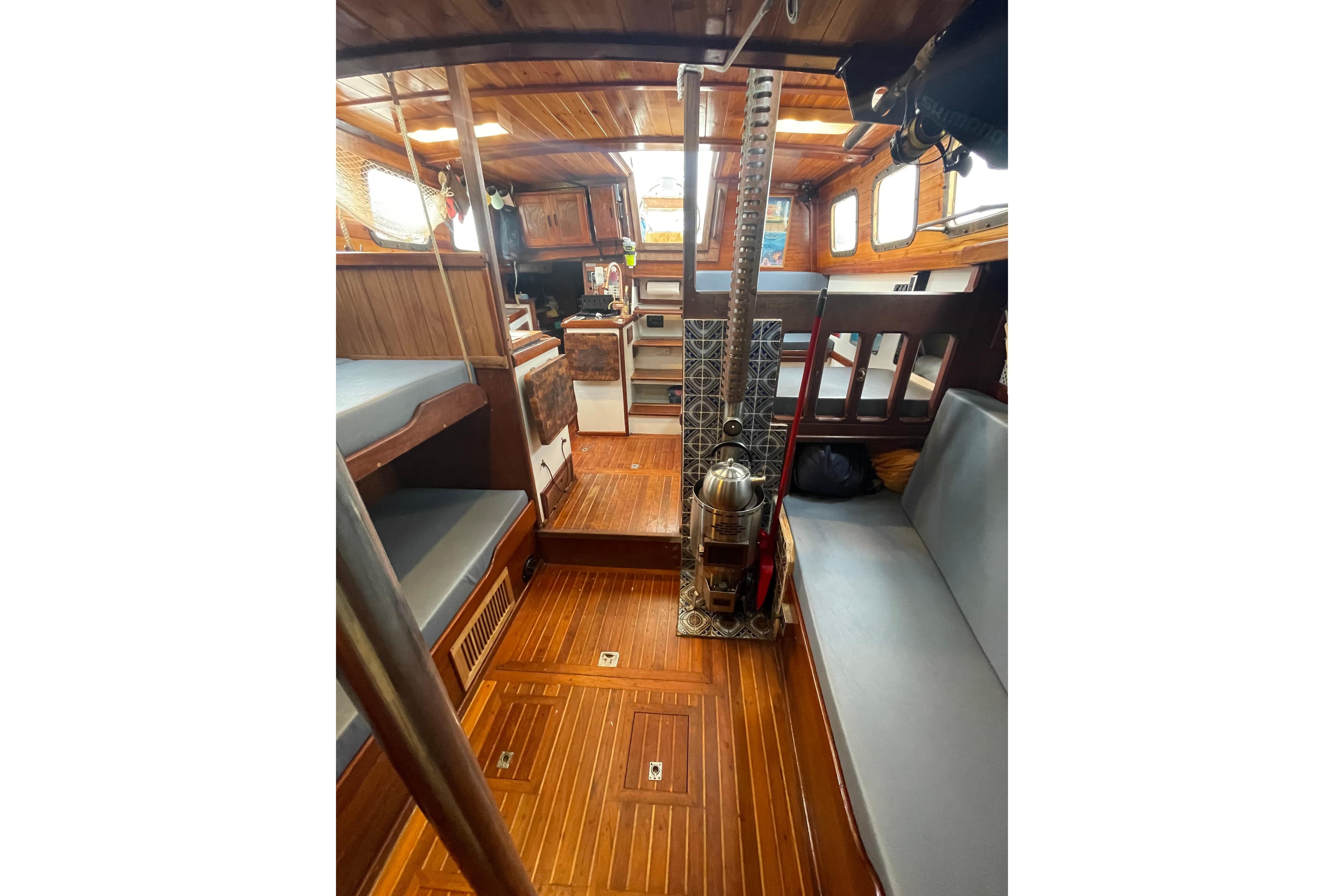Interior of 1975 Westsail Staysail Ketch with wooden flooring and cozy seating.