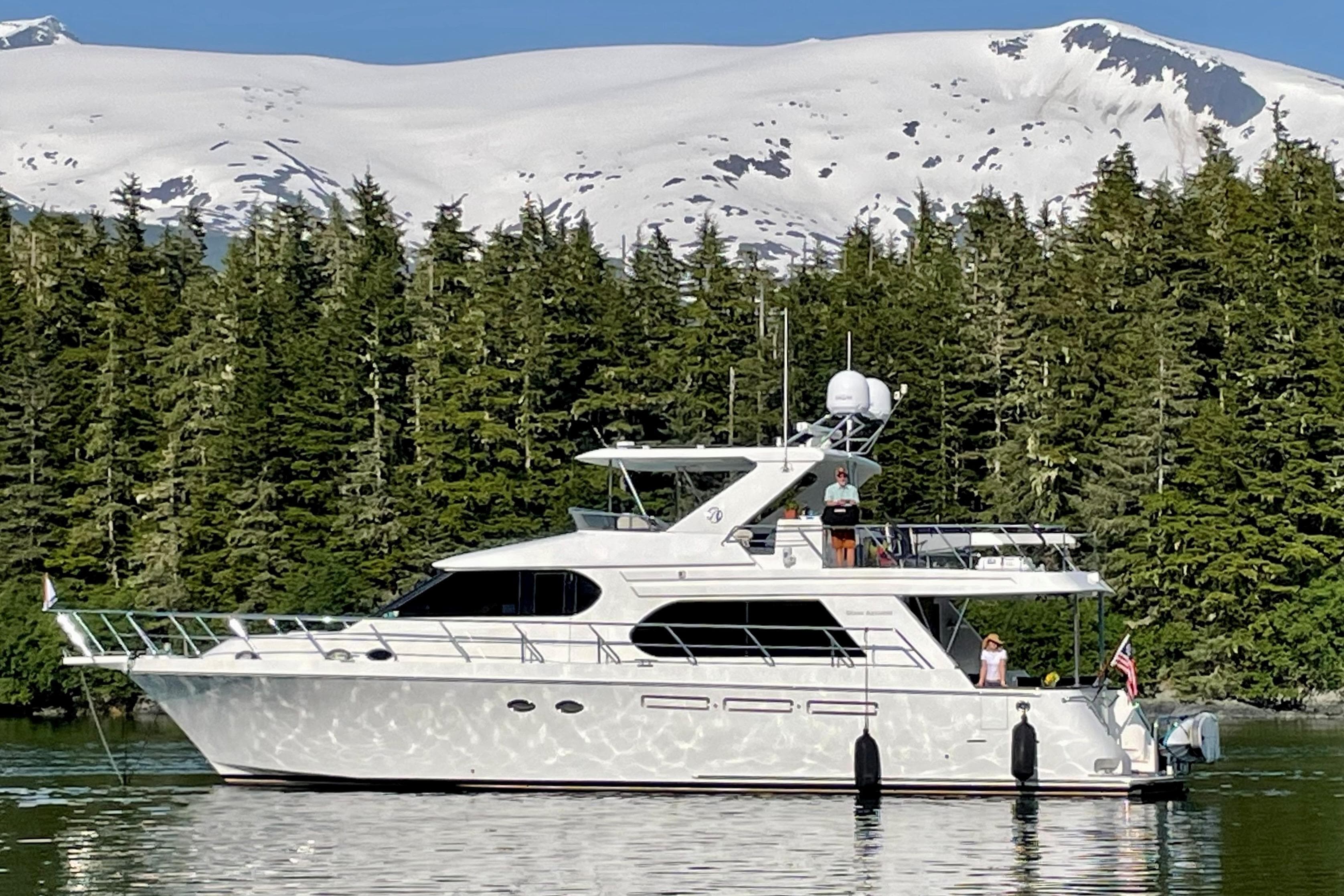 2007 Ocean Alexander 58 Motoryacht cruising near snowy mountains and lush forest.