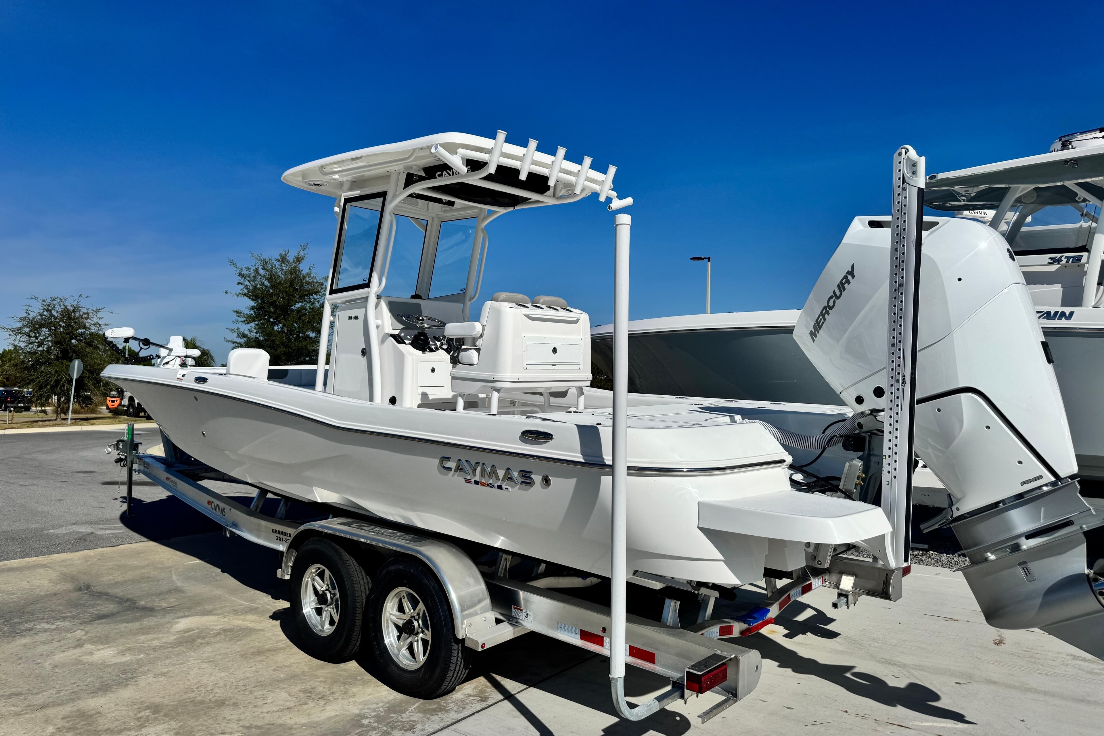2026 Caymas 28 HB boat on trailer with Mercury engine, parked outdoors.