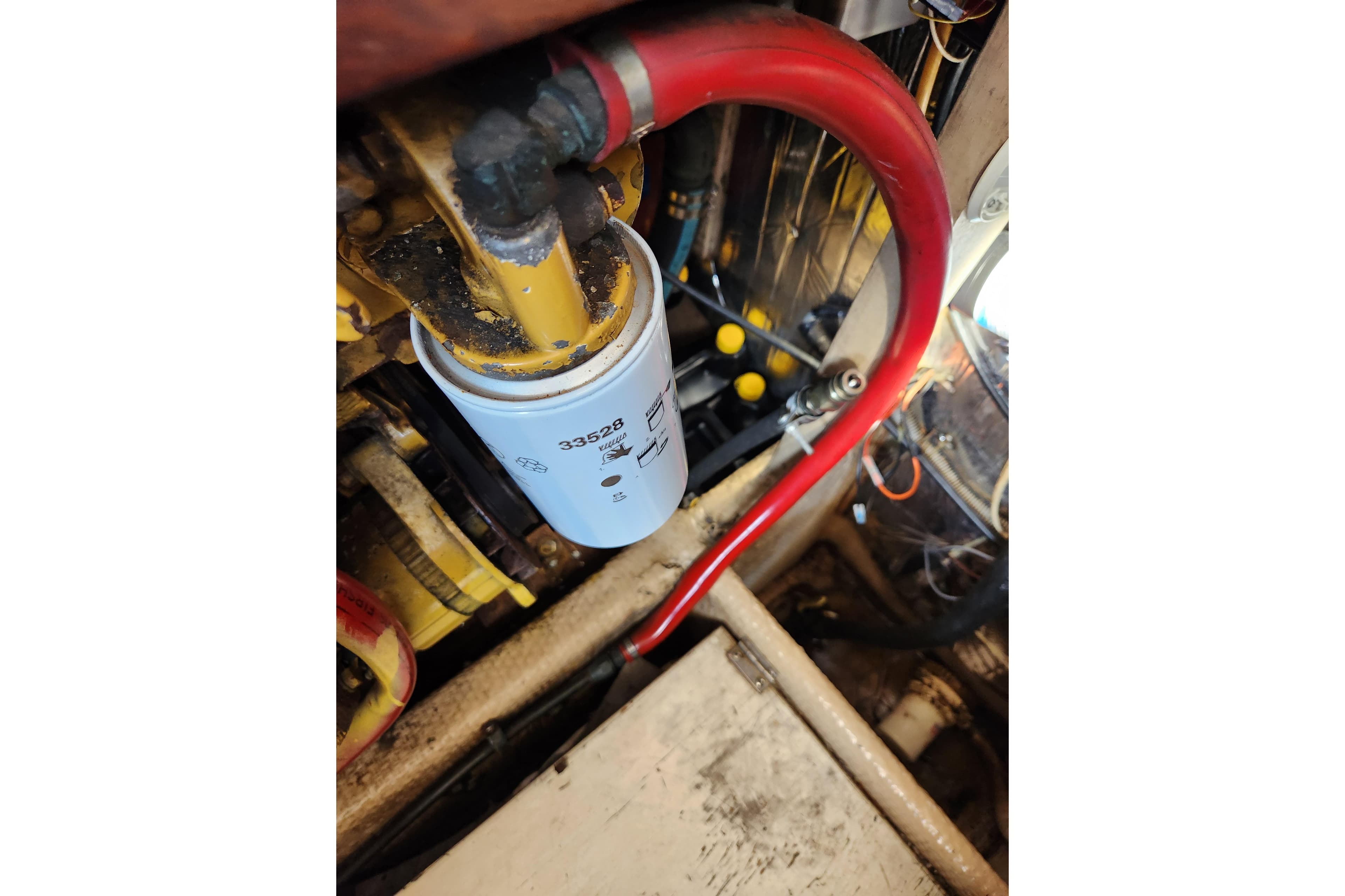 Engine compartment of 1987 Luhrs 40 Convertible with visible fuel filter and red hose.