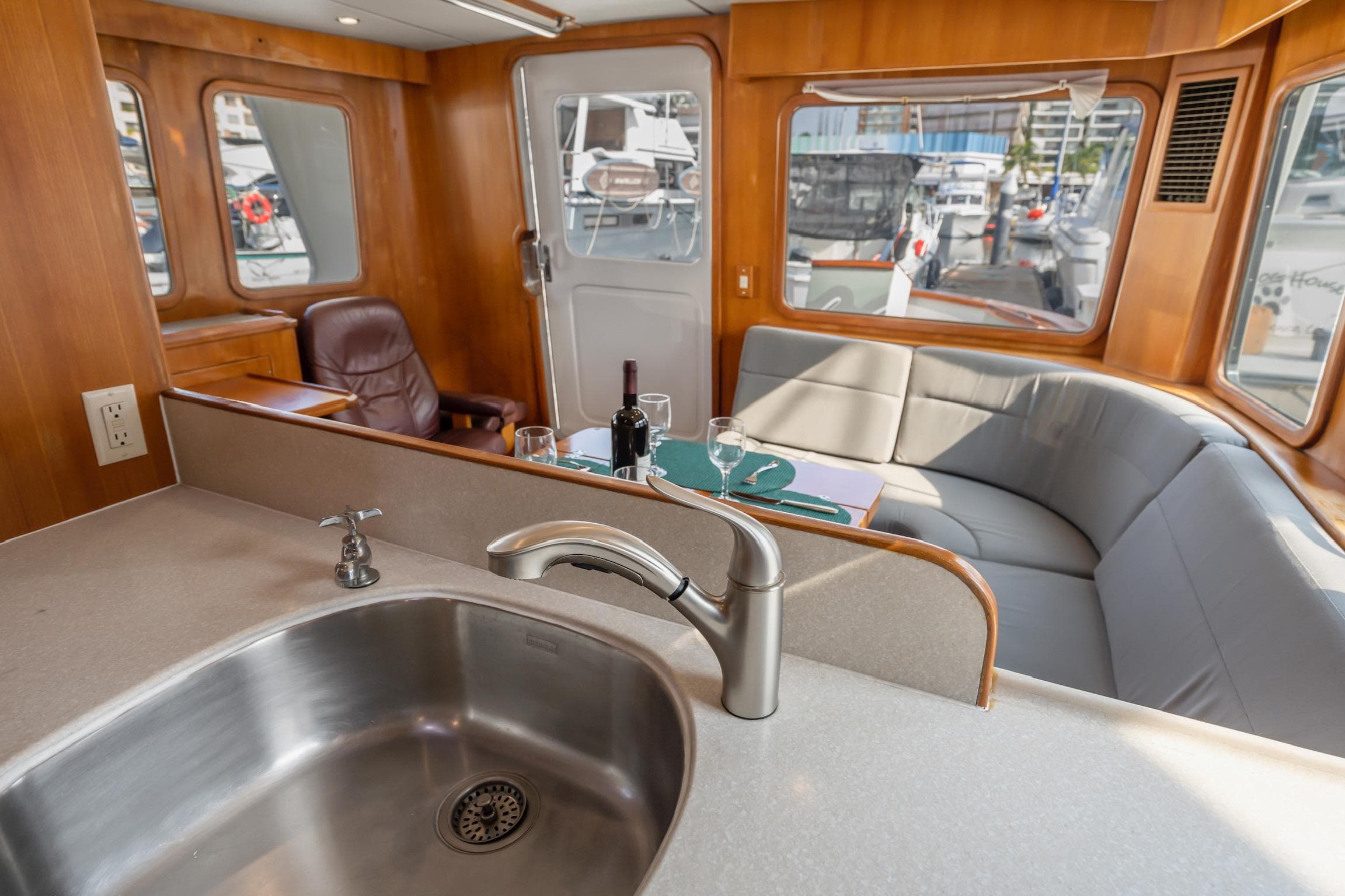 Interior of 2003 Nordhavn 46 yacht with kitchen sink, seating area, and marina view.